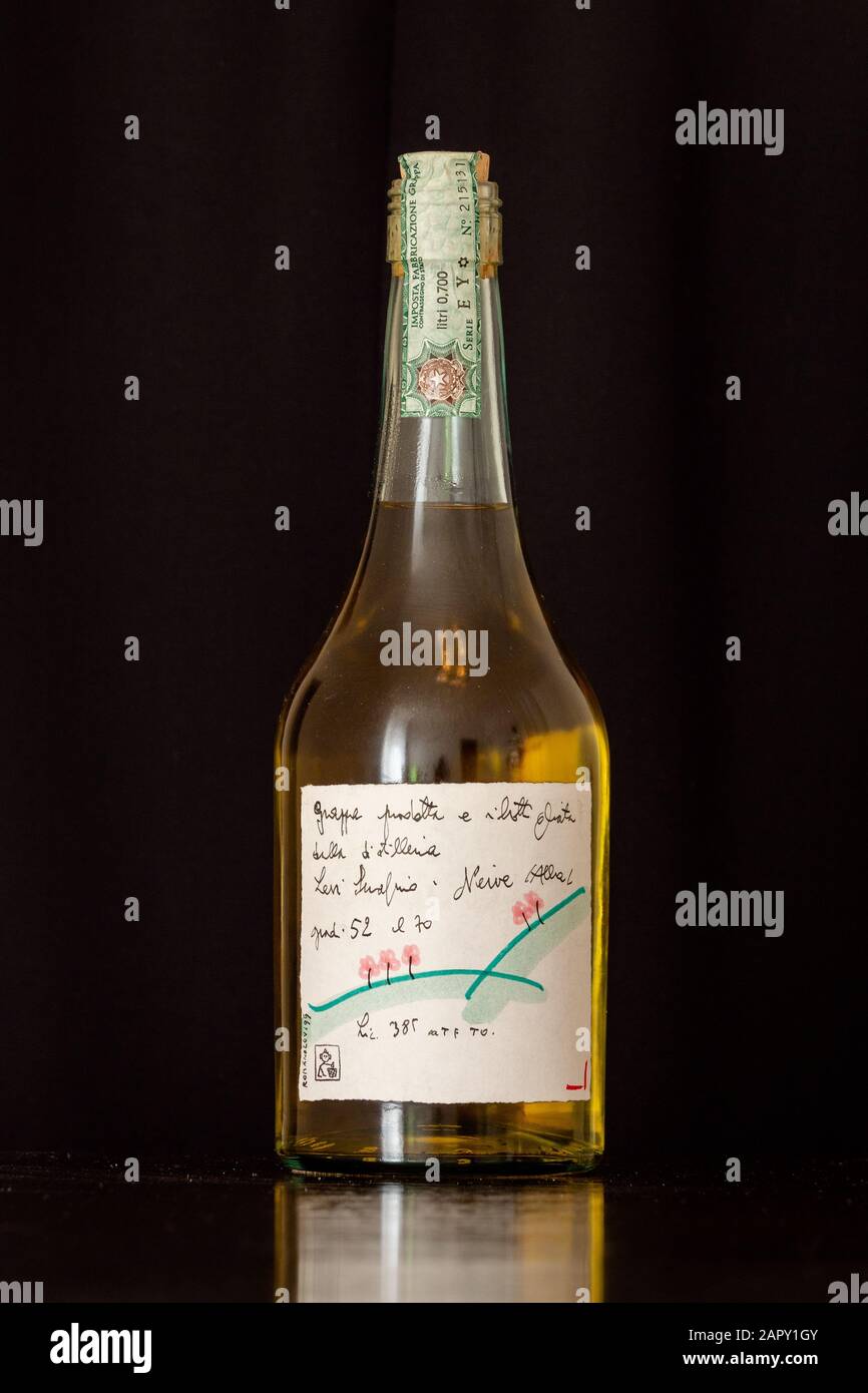Neive, Alba, Italien - 12. Januar 2020: Original Romano Levi Grappa Flasche mit Zeichnung aus dem Jahr 1995 auf schwarzem Hintergrund. Stockfoto