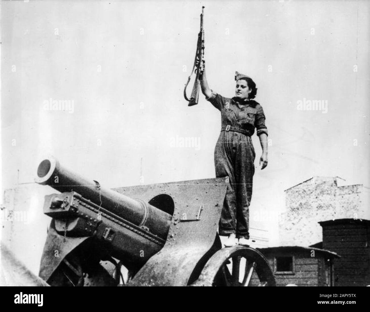 Während des spanischen Bürgerkrieges sind sogar Frauen an den Waffen. Die Frauen sind auch beim Umgang mit der Waffe qualifiziert. Barcelona. 1936... Frau mit Gewehr in der Nähe eines Kanons. Spanischer Bürgerkrieg. Barcelona, 1936. Stockfoto
