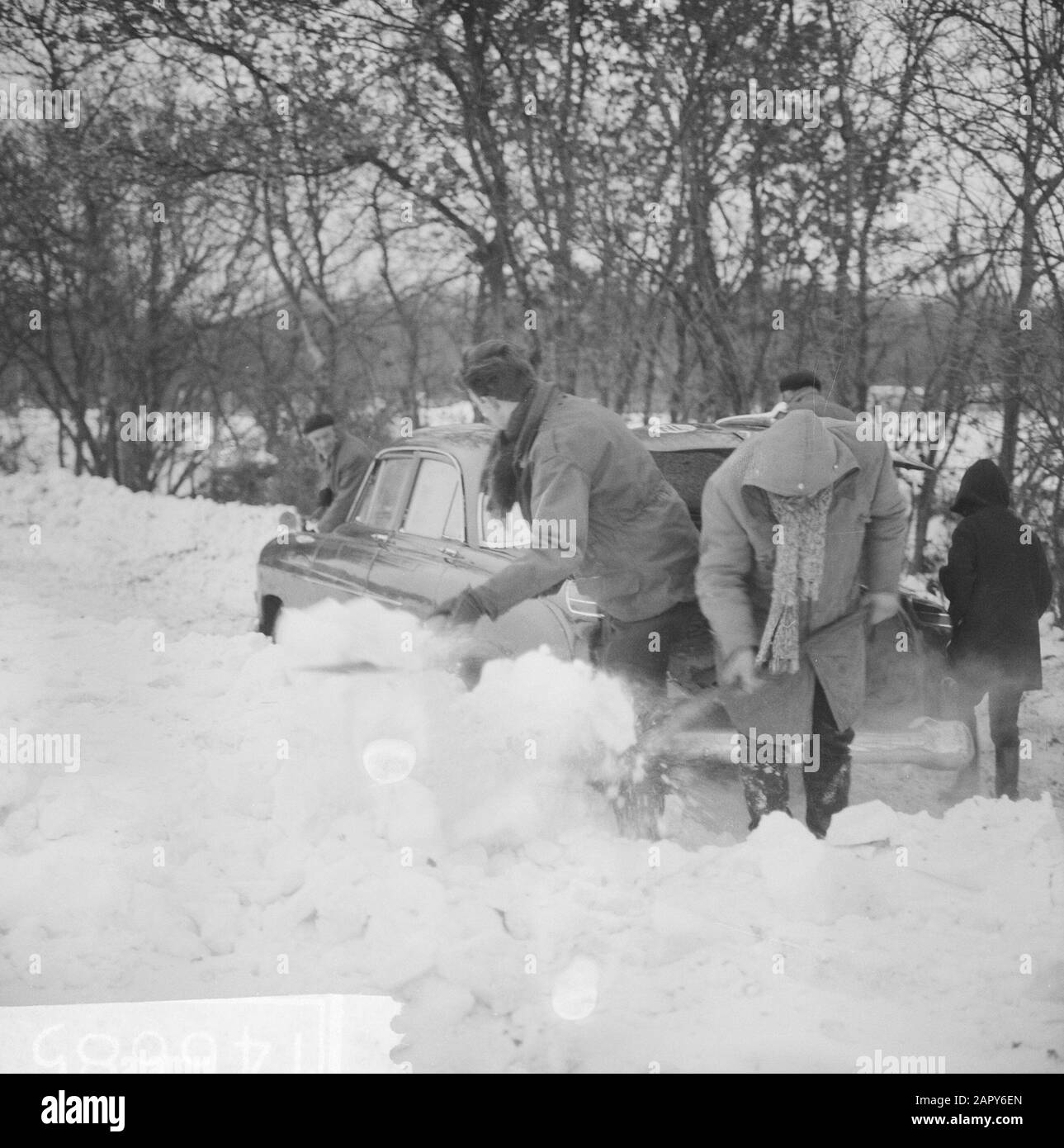 Schneite Autos, Menschen, die ausgraben Datum: 1. Januar 1963 Schlüsselwörter: Menschen, Autos, Schnee Stockfoto