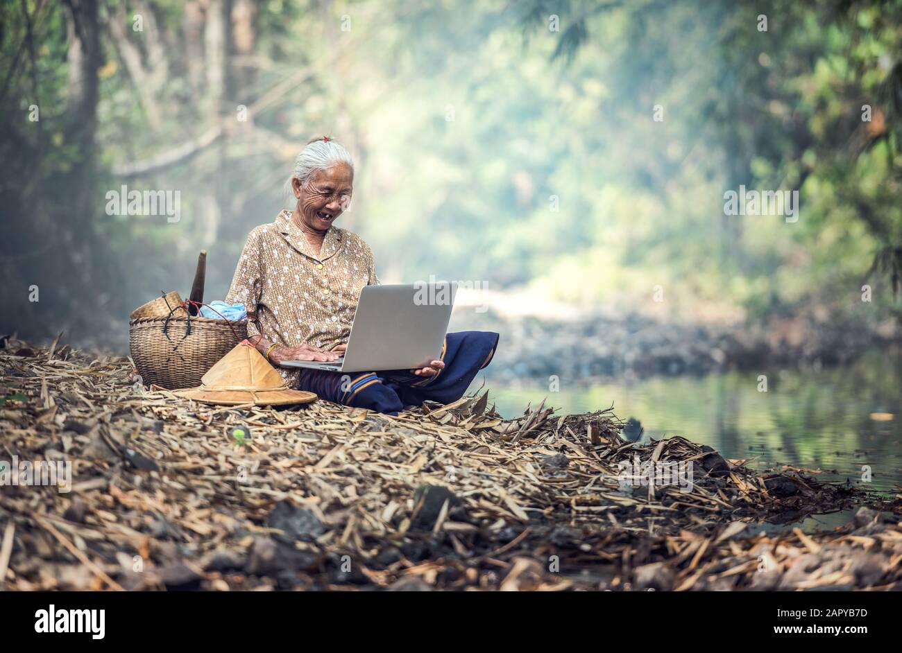 Alte Frau, die einen Laptop im Freien verwendet Stockfoto