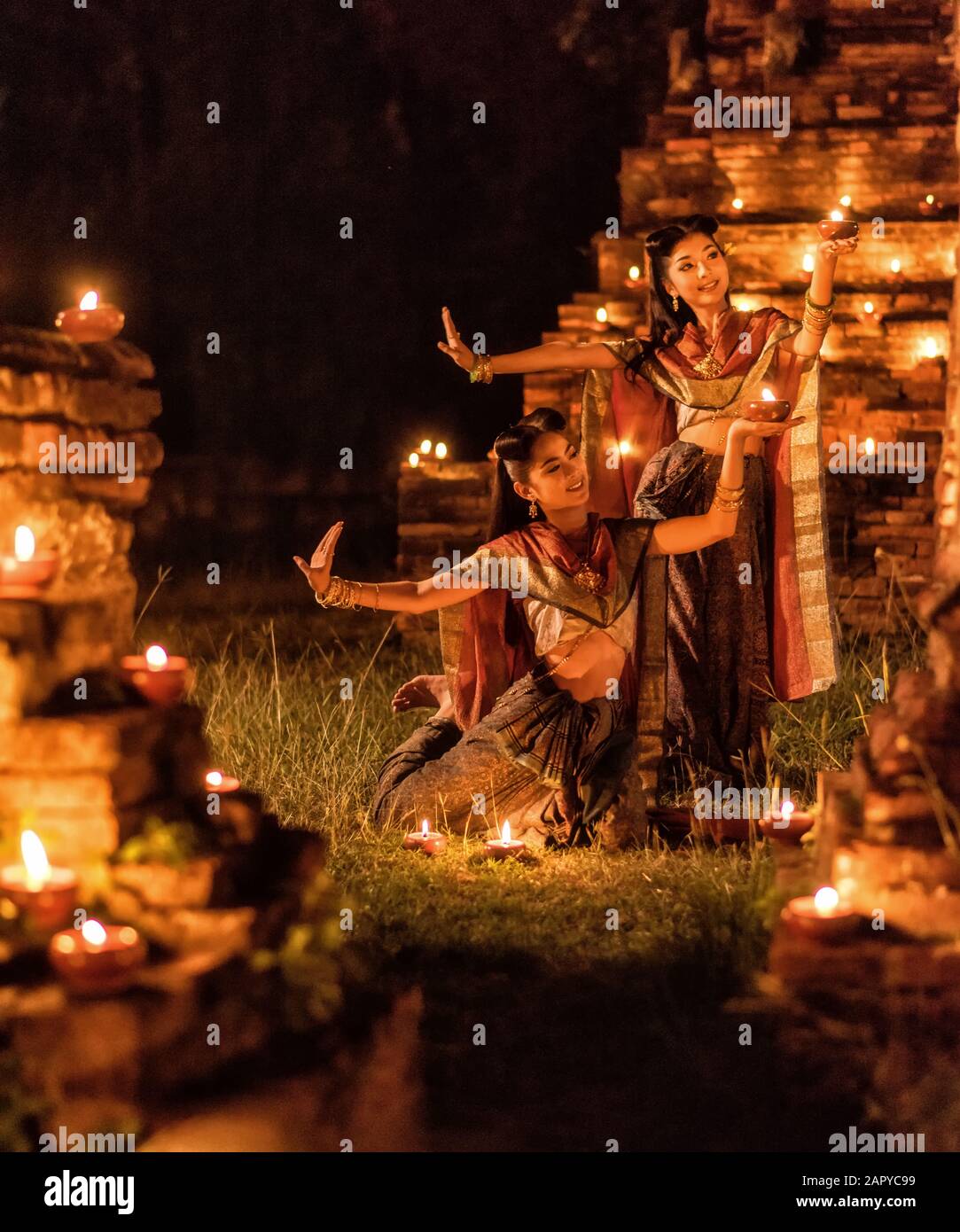 Thailändisches Mädchen im Ayutthaya-Stil, nachts mit Kerze Stockfoto