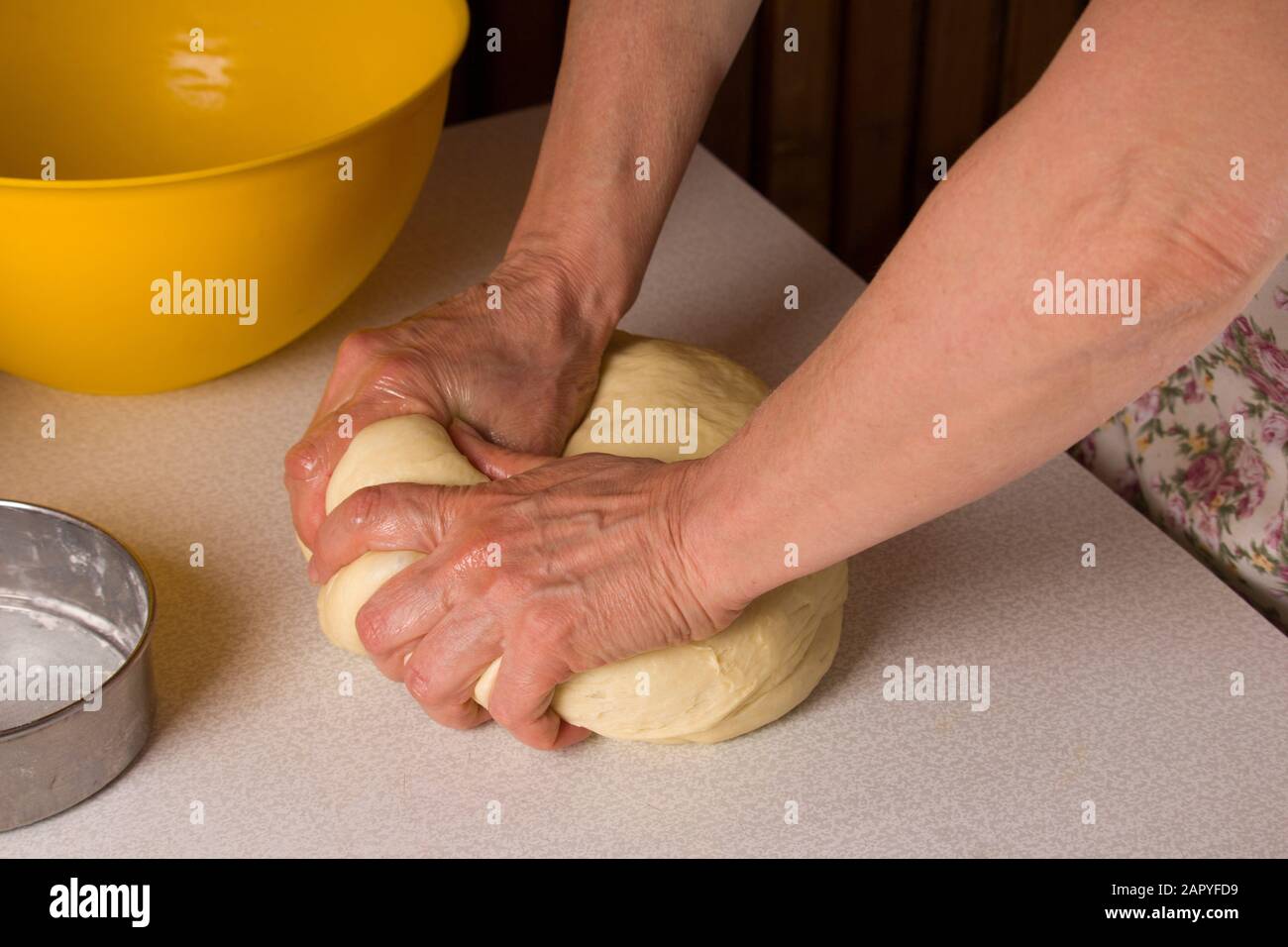 Teig von Hand auf dem Holztisch kneten. Kochen, Kochen. Stockfoto