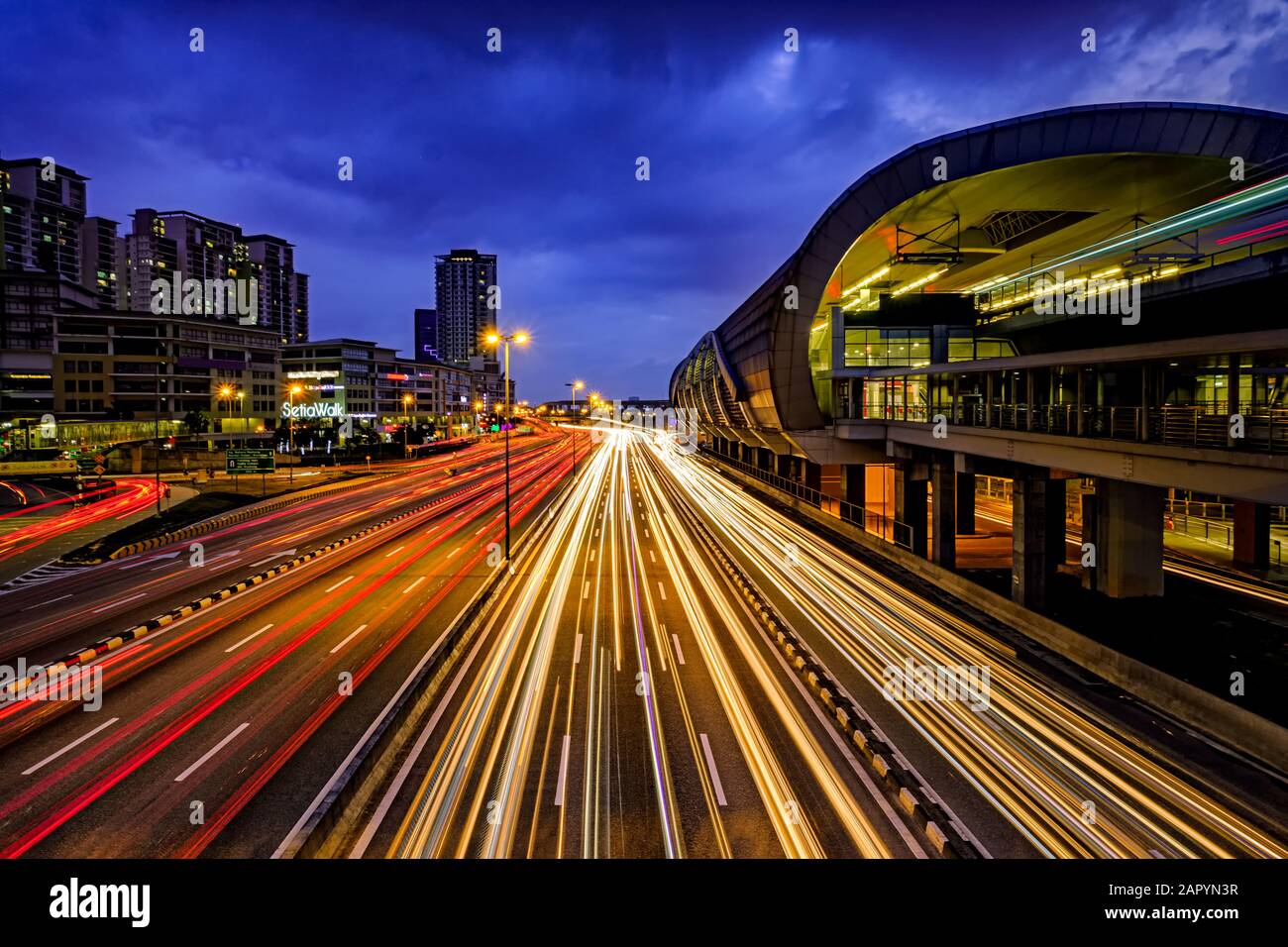 Puchong, Selangor, Malaysia - 14. Januar 2018: Blick Auf Die Landschaft einer Lichtsefahrt zu blauer Stunde auf einem verkehrsreichen Verkehrsnetz und LRT-Station auf der rechten Seite mit Stockfoto