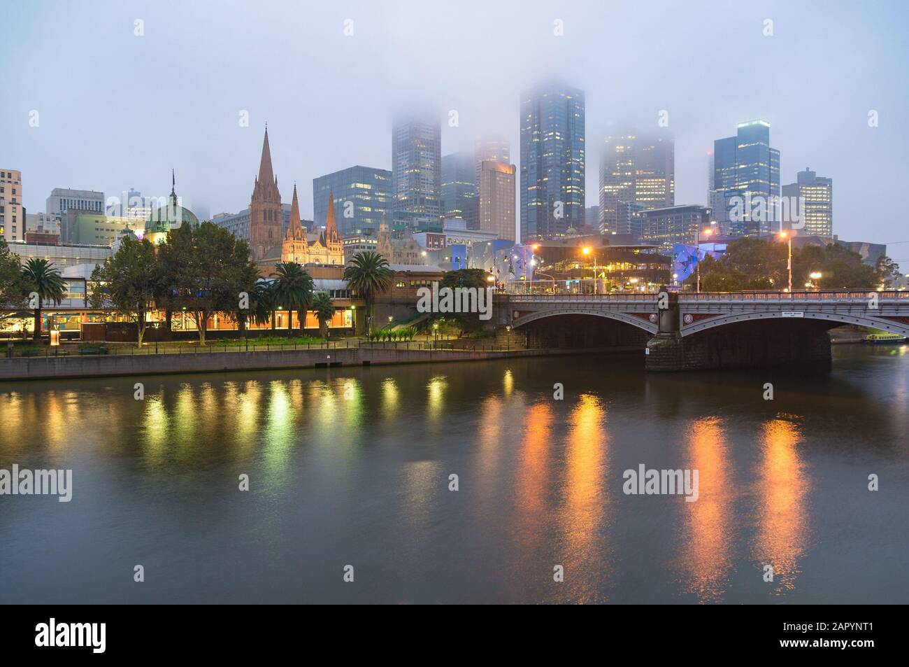 Wunderschönes Stadtbild Melbournes am Morgen mit niedrigen Wolken, Nebel und Lichtern, die sich im Yarra River widerspiegeln. Melbourne, Australien Stockfoto