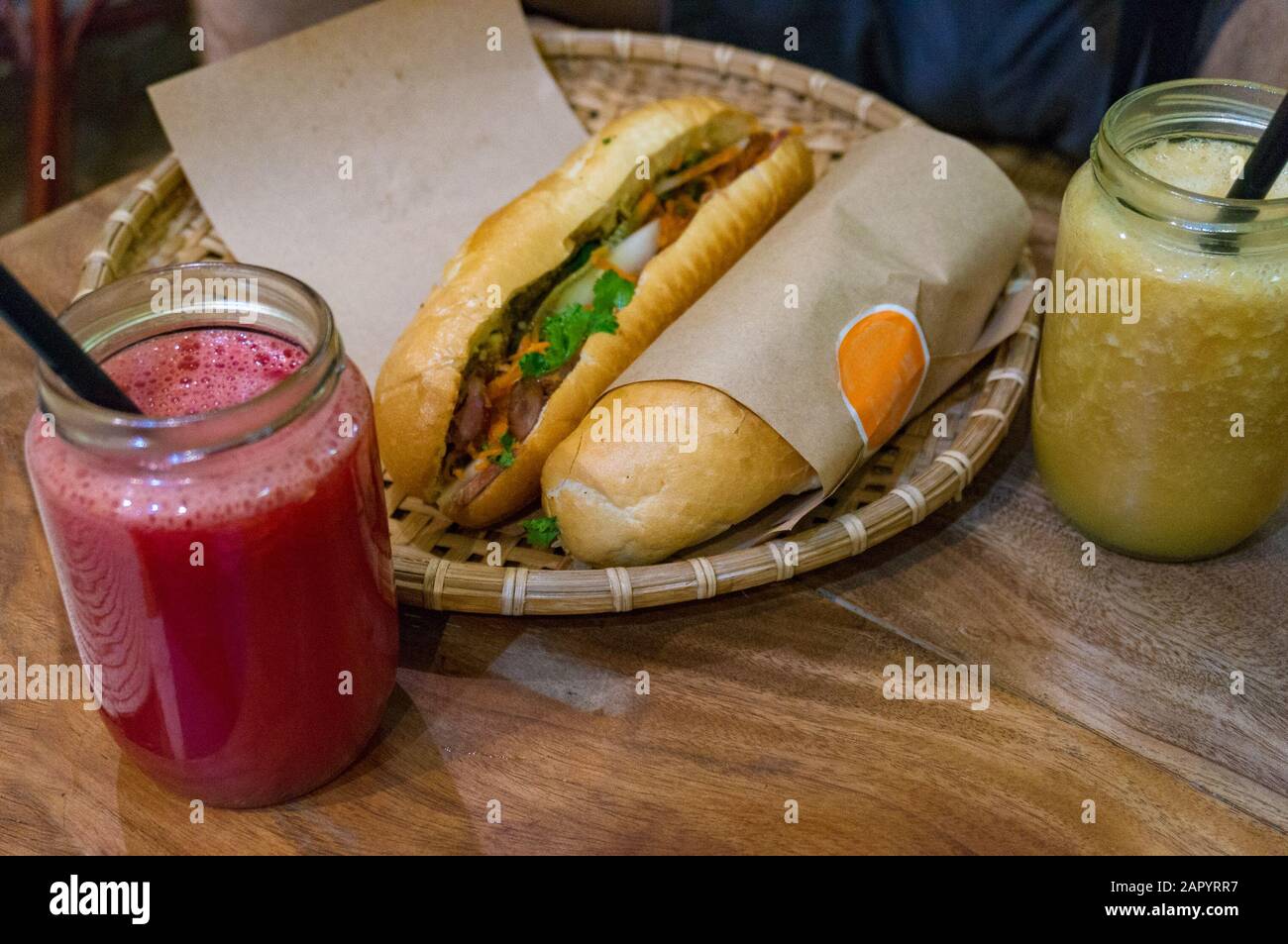 Traditionelles vietnamesisches Banh Mi Sandwich mit Fruchtsmoothie-Getränk Stockfoto