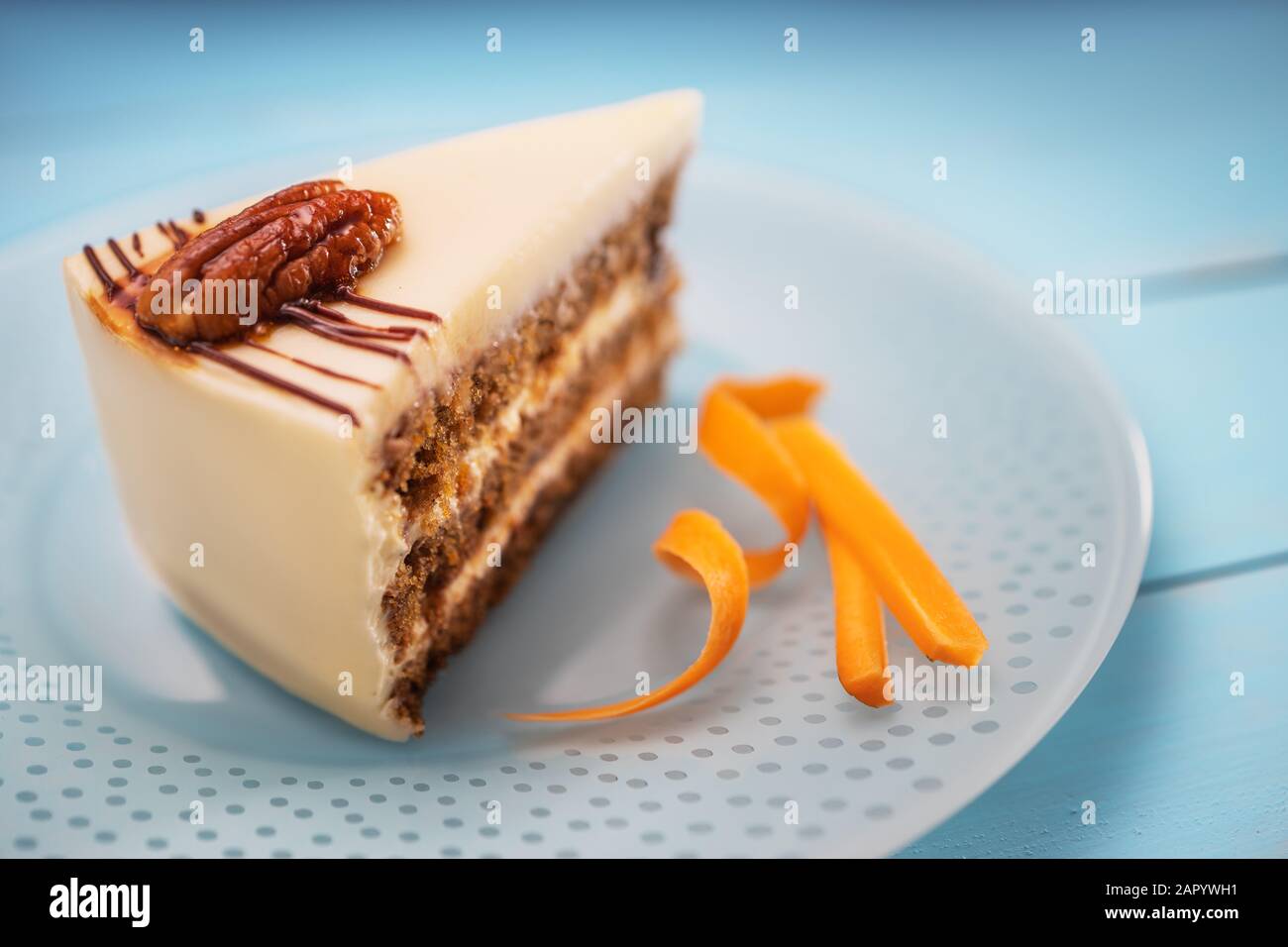 Kuchen Stück mit Schokolade, Milch, Sahne, Karotten und Muttern auf einem blauen Platte isoliert Stockfoto