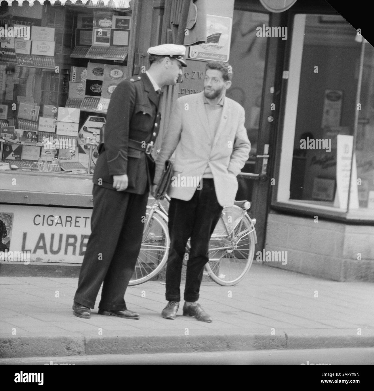 Mann mit Platte nach Festnahme. Fälschungsklage. Agent sumiert Junge, der durch Datum gehen soll: 21. Juni 1961 Stichwörter: Fälschung, Agenten, Klagen Stockfoto