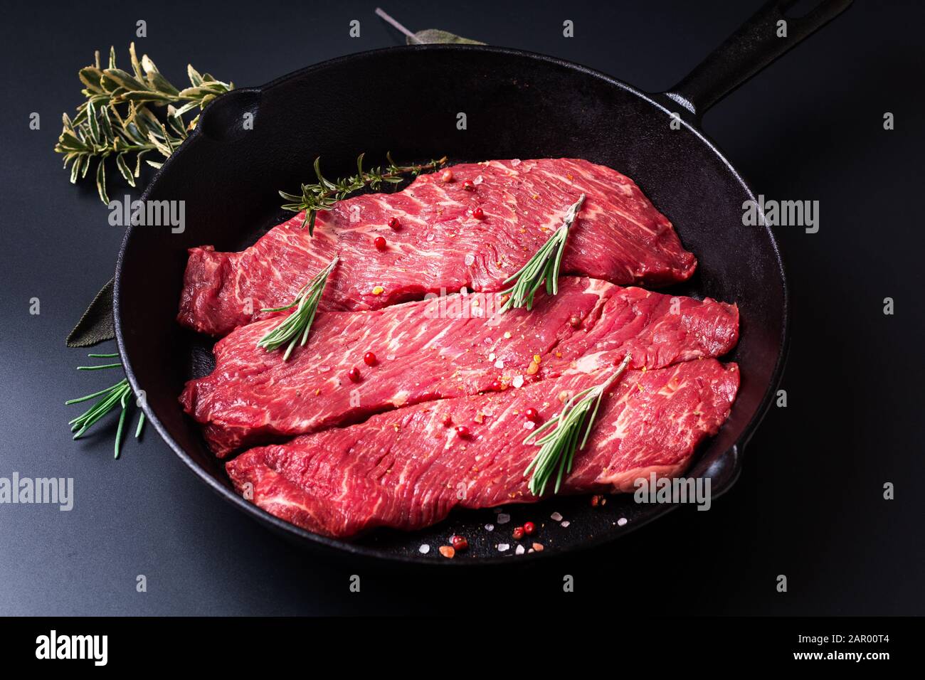 Lebensmittelkonzept Bio Rohfleisch Filet Beef Steak in Skillet Eisen-Pfanne auf schwarzem Hintergrund Stockfoto