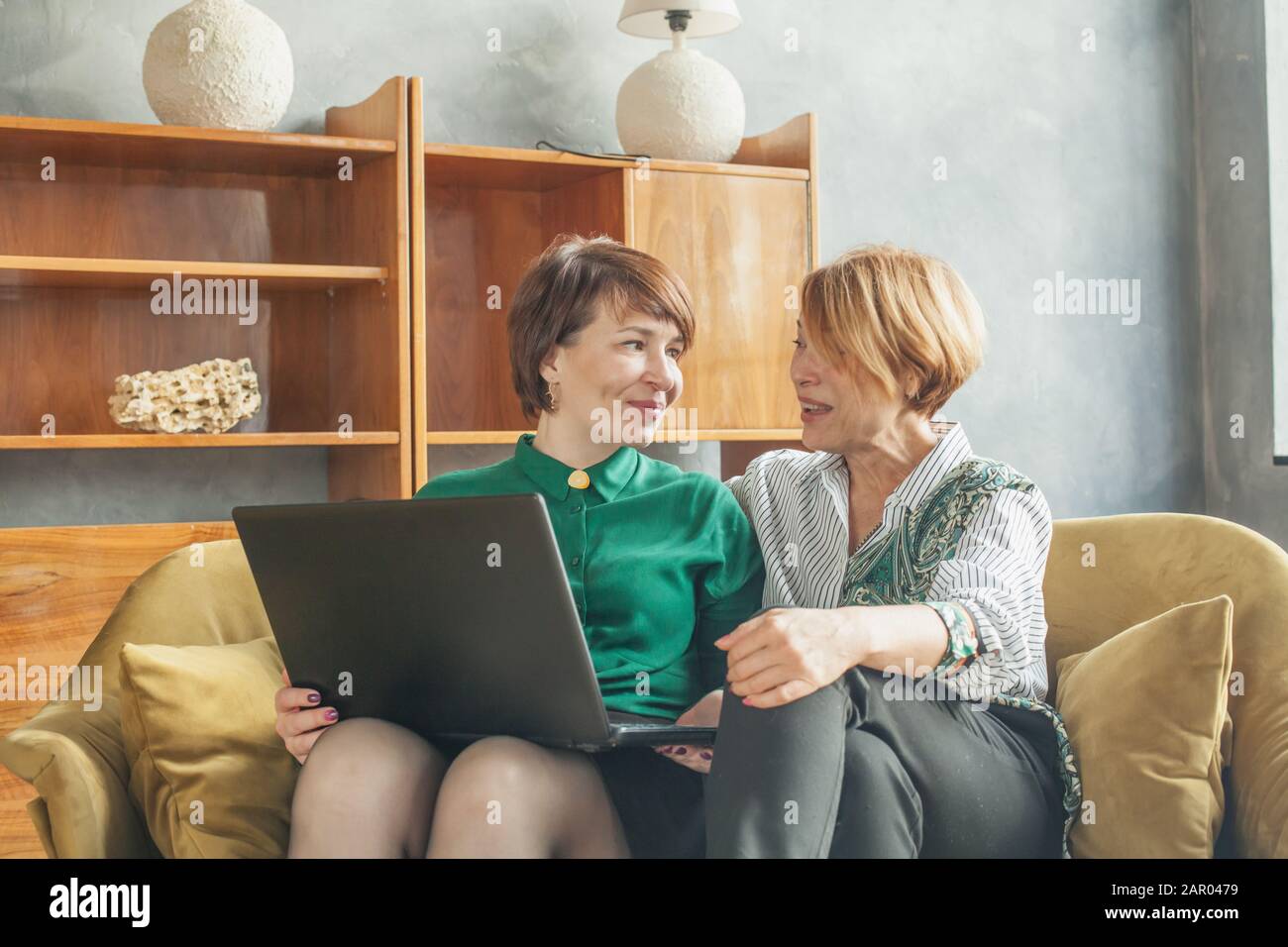 Glückliche, reife Frauen, die zu Hause mit einem Laptop chatten und  arbeiten Stockfotografie - Alamy