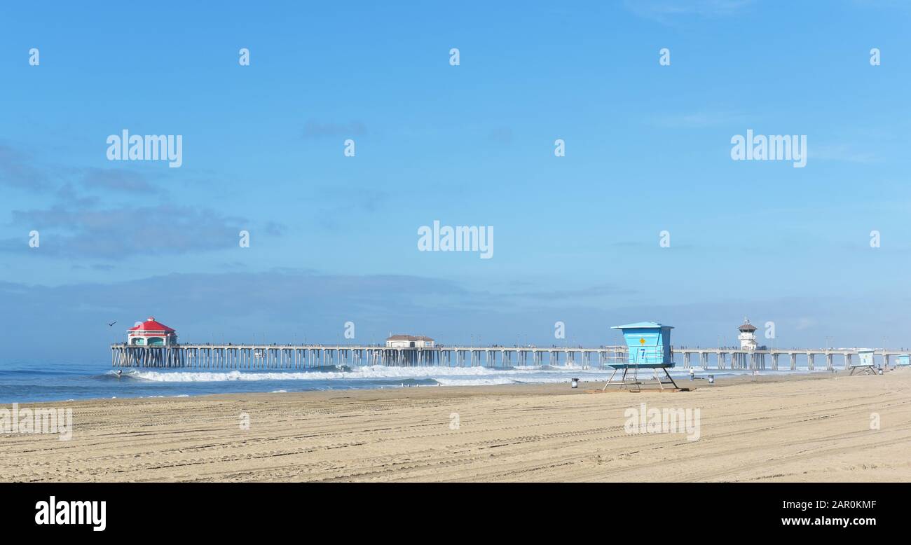 HUNTINGTON BEACH, KALIFORNIEN - 22. JANUAR 2020: Der Huntington Beach Pier mit Surfern im Wasser. Stockfoto