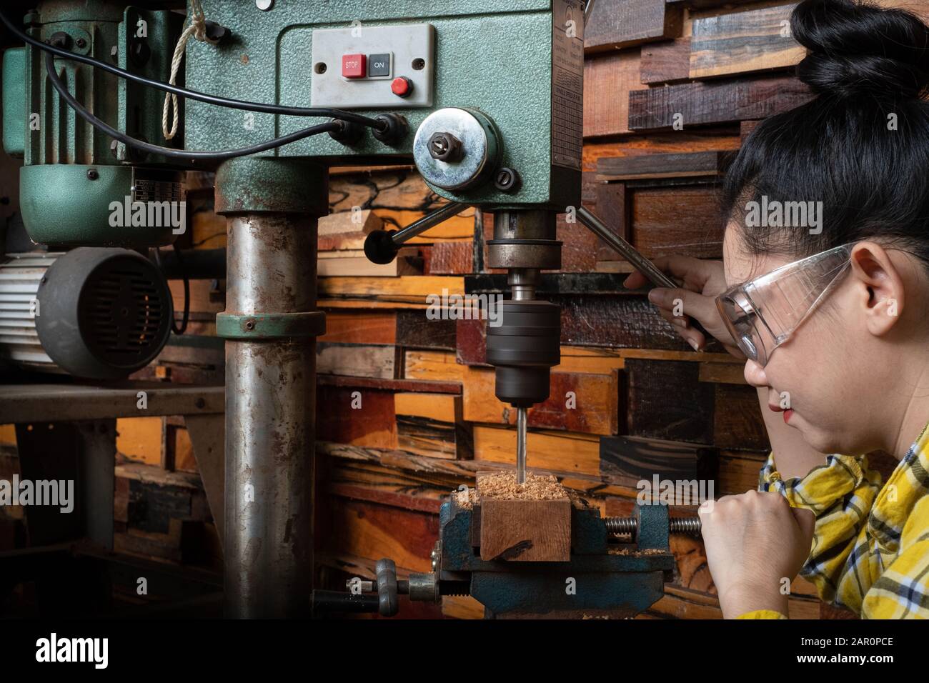 Frauen stehen ist handwerklich arbeitendes Bohrholz auf einer Werkbank mit  Bohrmaschine Presskraft Werkzeuge bei Tischlermaschine in der Werkstatt  Stockfotografie - Alamy