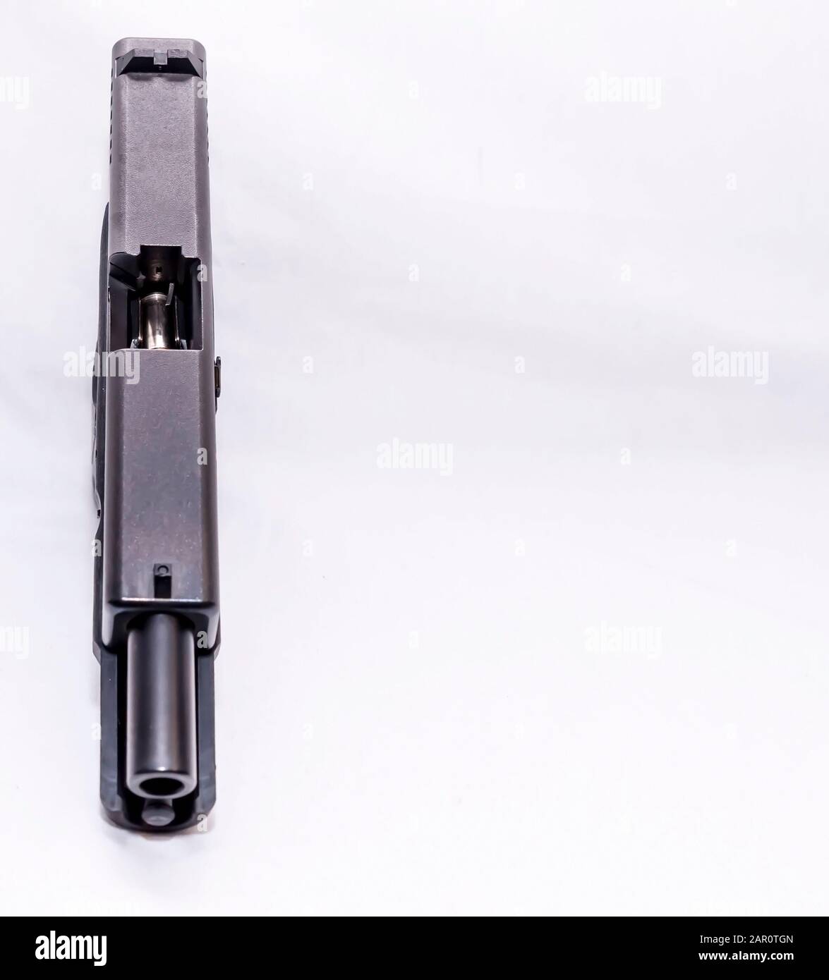 Eine schwarze halbautomatische 9-mm-Pistole mit einem geöffneten Objektträger, der ein Geschoss im Magazin auf weißem Hintergrund mit Kopierraum zeigt Stockfoto