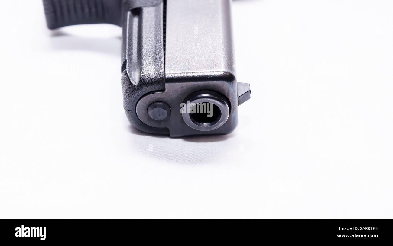 Die Schnauze einer schwarzen halbautomatischen 9-mm-Pistole mit weißem Hintergrund Stockfoto