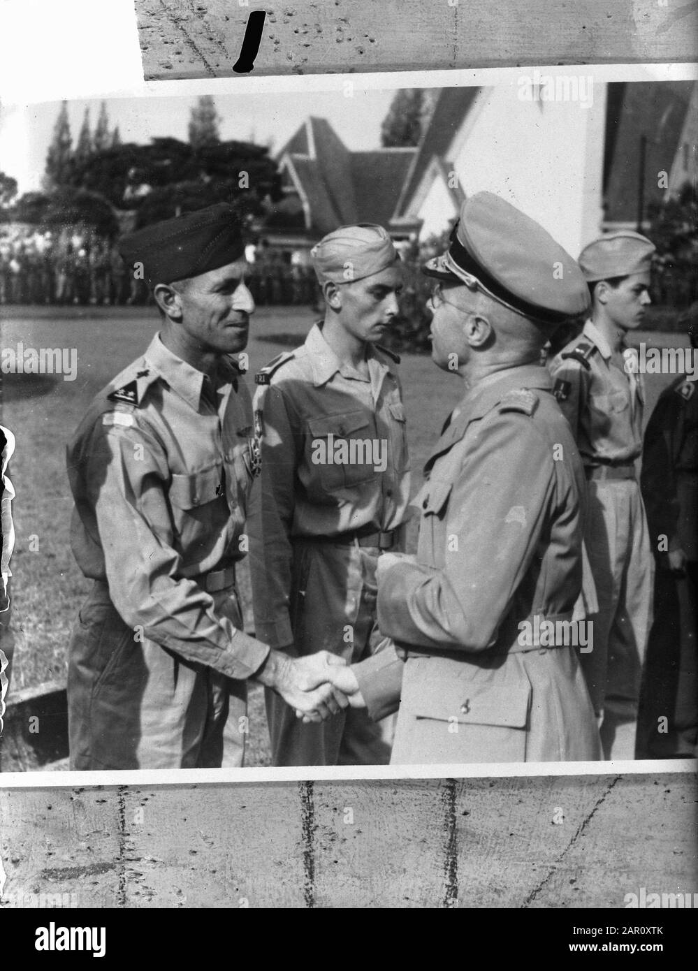 Auf dem Bürgermeisterplatz in Batavia, Vertreter der Krone in Indonesien, Dr. L.J.M. Beel, besitzt die Dekorationen, die zur 4. Klasse des Rittergutes des Militär-Orden von William gehören, die an fünf Mitglieder der KNIL und zwei der Königlichen Armee verliehen werden. Er schüttelt die Hand des dekorierten Oberstleutnant-Piloten-Beobachters R.E. Jesserun Anmerkung: Die Anordnung von William wurde auf der K.B vom 16. November 1948 Nr. 13 erteilt. Jessurun kam am 14. Mai 1949 in Kroja (Java) am 19. März 1949 in einen Flugzeugabsturz: Standort: Batavia, Indonesien, Jakarta, Niederländisch-Ostindien Personenname: Beel, L.J.M., Jesserun, Stockfoto