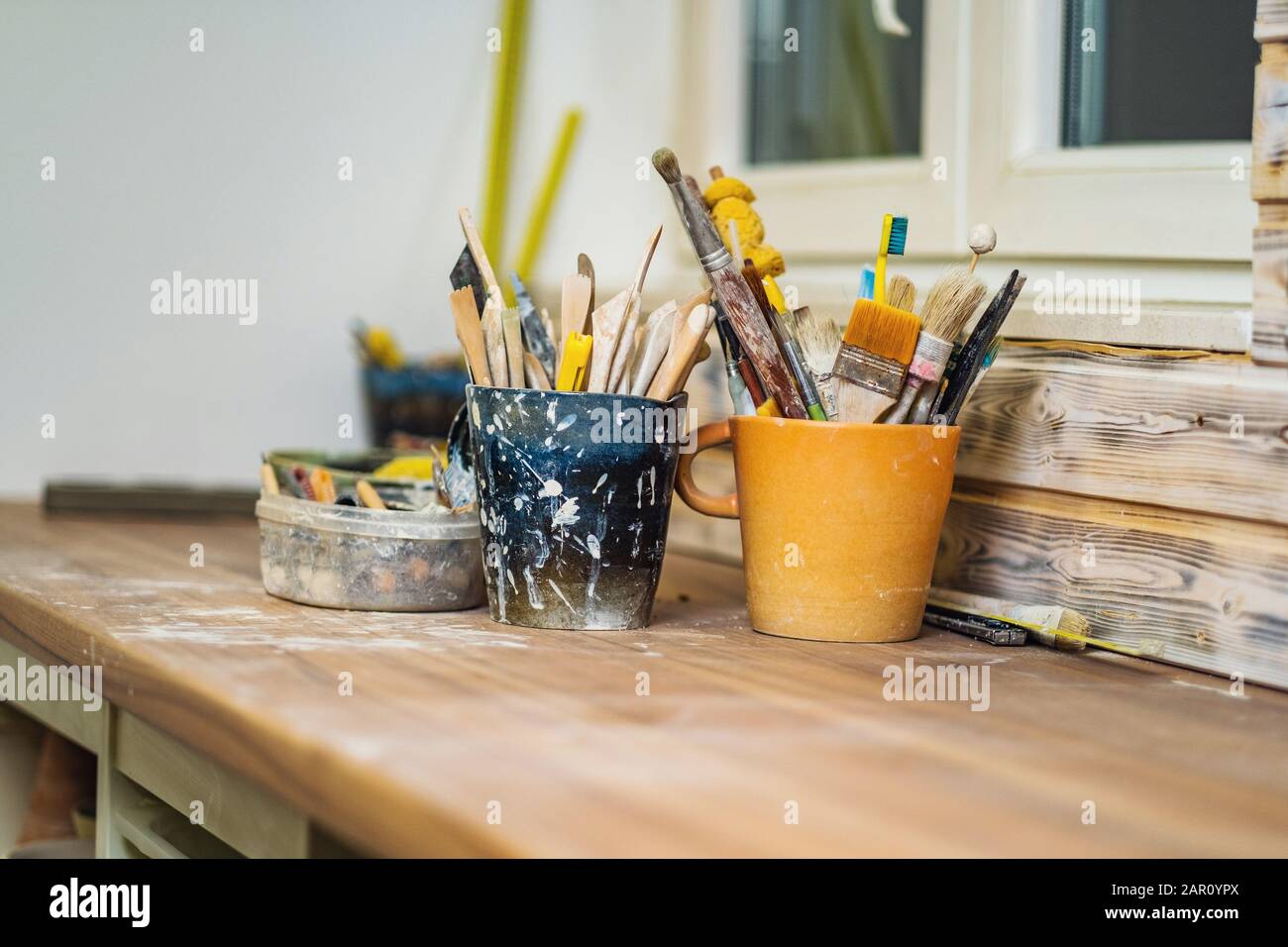 Handgefertigte Platten, Backen und Werkzeuge auf Tonstudiotisch, flache Verschuldung des Feldes, Kleinkunstgeschäftskonzept Stockfoto