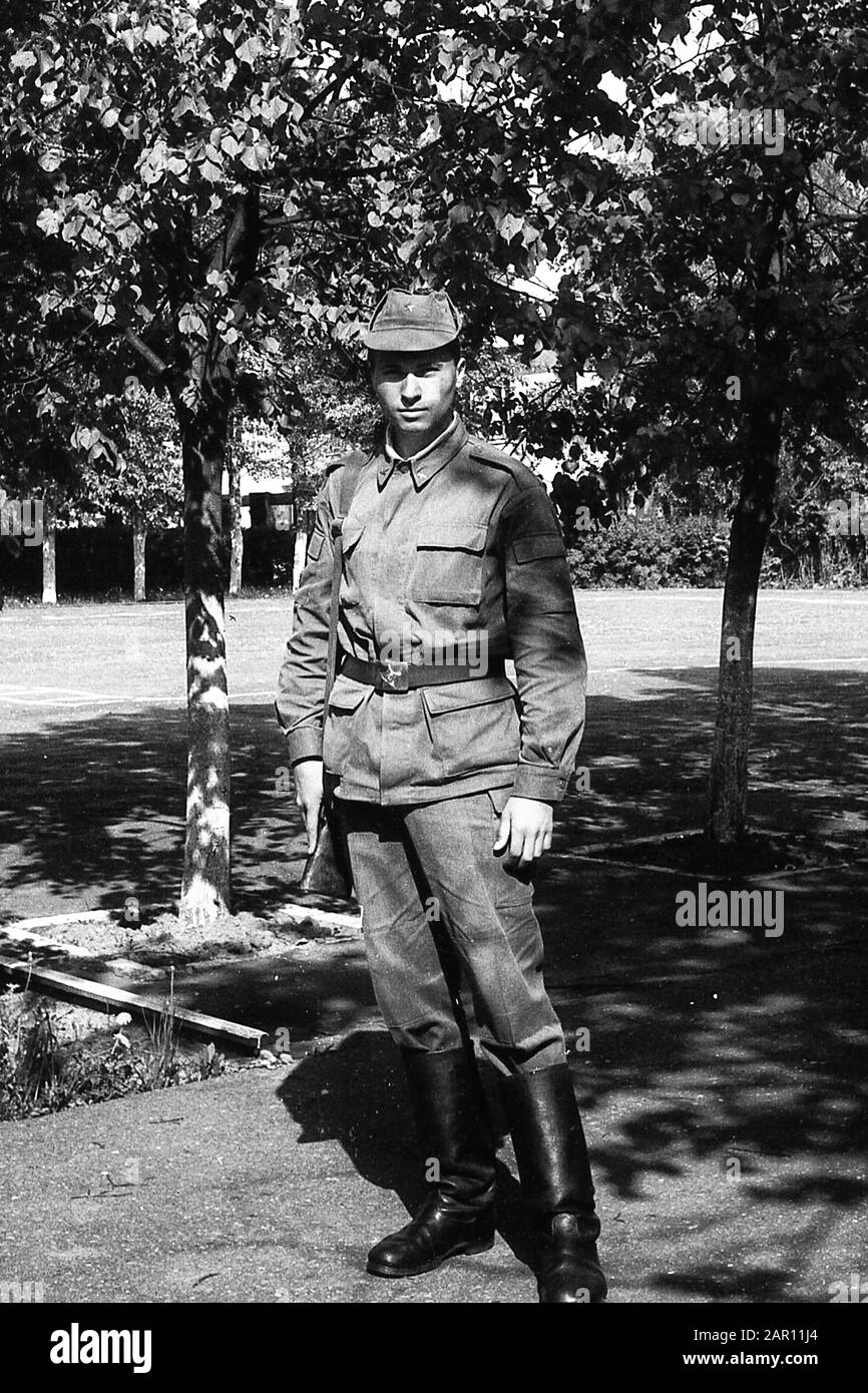 STUPINO, REGION MOSKAU, RUSSLAND - CIRCA 1992: Porträt eines russischen Soldaten der Armee, der mit einer Waffe (Karbin) auf dem Paradeplatz steht. Schwarz und Weiß. Filmscan. Große Körnung. Stockfoto