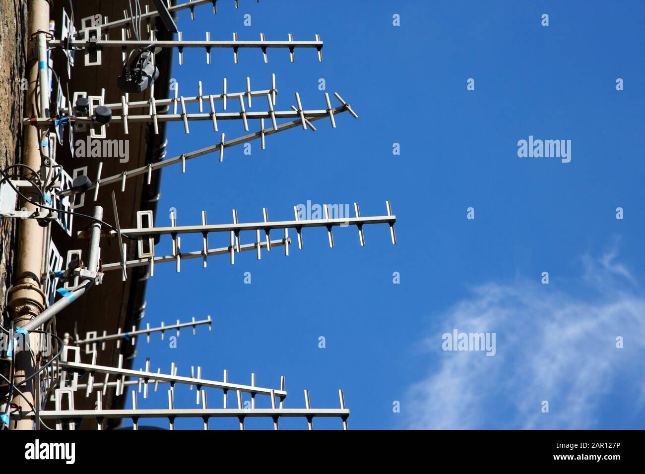 Anordnung von Fernsehantennen an der Wand eines Mietskastenblocks in schottland vor blauem Himmel Stockfoto