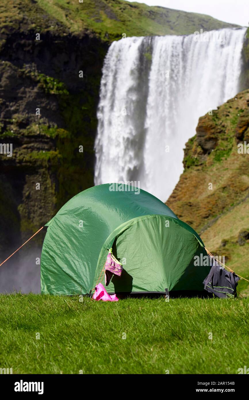 Kleines Zelt für zwei Personen mit Kleidung, die beim Wasserfall Island im Skogafoss zelten Stockfoto
