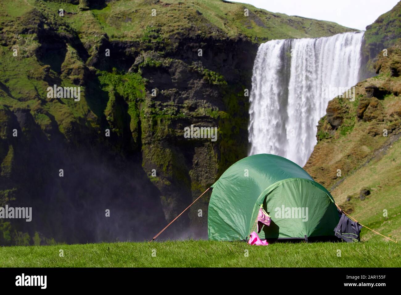 Kleines Zelt für zwei Personen mit Kleidung, die beim Wasserfall Island im Skogafoss zelten Stockfoto