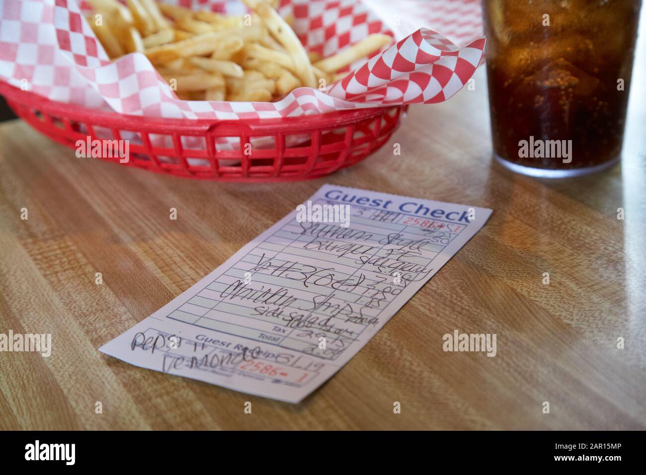 Korb mit Pommes-Cola-Getränk und Check in Rechnung für eine Mahlzeit in einem amerikanischen restaurant Stockfoto