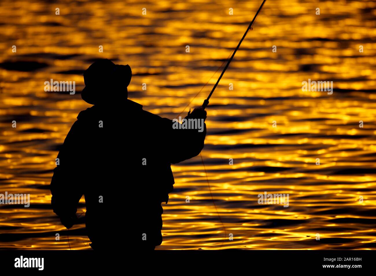 Fischer fliegen Angel-Casting auf Stoneyford Reservoir bei Sonnenuntergang, County antrim Nordirland während der goldenen Stunde im Herbst Abend UK Stockfoto