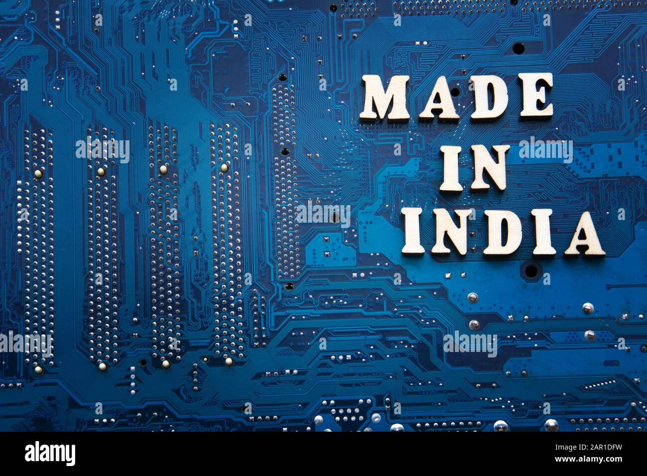 Beschriftung In Indien auf blauem Leiterplattenhintergrund. Copyspace für Design. Label made in India Electronics Manufacturing Concept Stockfoto