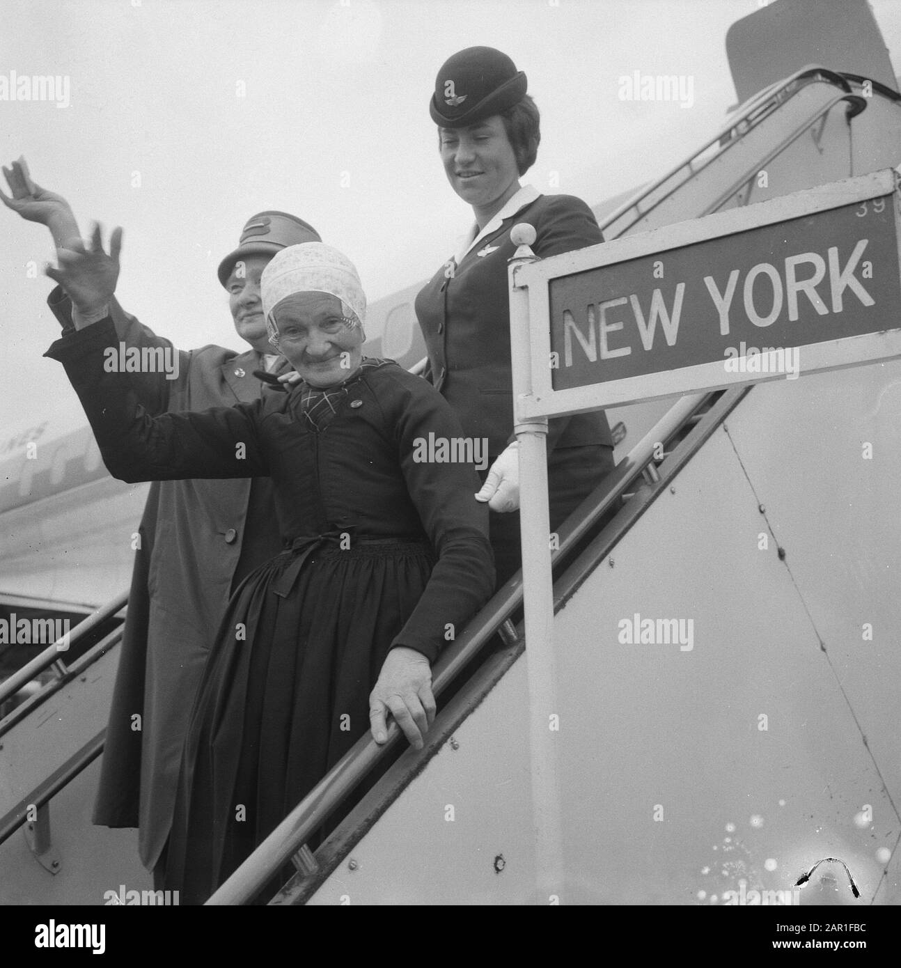 Maartje Velleke - den Herder (84 Jahre alt) auf Schiphol während ihrer Abreise nach Kalifornien in den Vereinigten Staaten, wo sie einen Familienbesuch macht, begleitet von ihrer Hilfe im Haushalt Frau Van Waard Maartje Velleke - den Herder schwenkt auf die Flugzeugtreppe Datum: 12. Oktober 1965 Ort: Noord-Holland, Schiphol Schlüsselwörter: An- und Abreise, ältere Menschen, Flugpersonal persönlicher Name: Velleke-Den Herder, Maartje, Waard, P. W. von Stockfoto