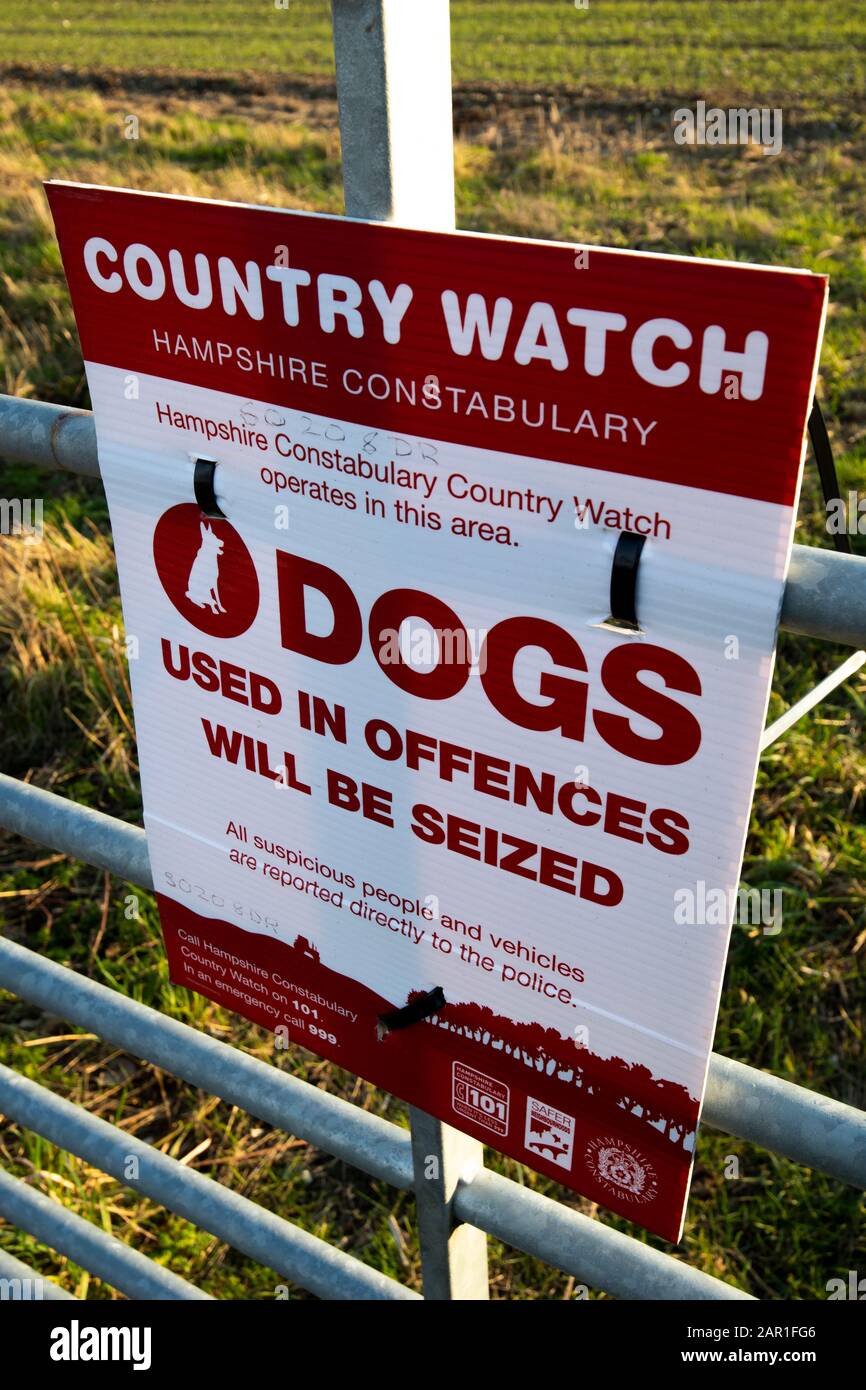 Die Landesuhr der Hampshire Constabulary arbeitet in diesem Bereich mit einem Hundeschild am Tor der Farm, um illegale Aktivitäten auf dem Land zu verhindern Stockfoto