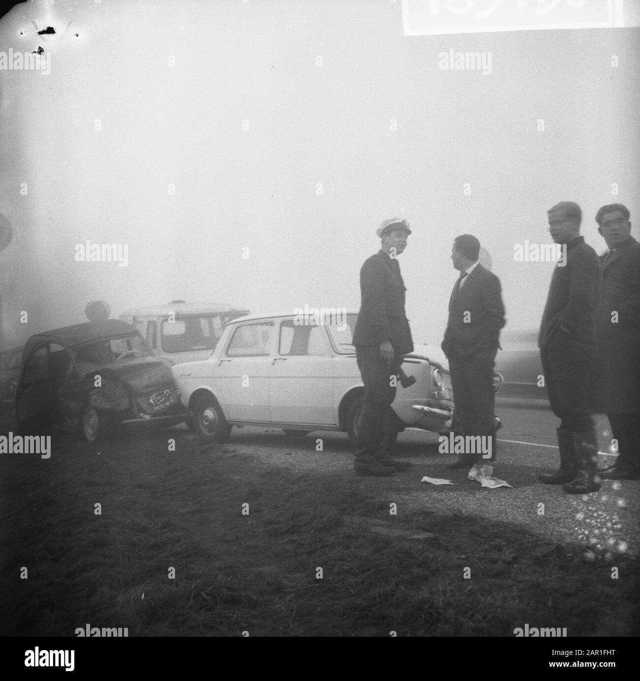Kettenzusammenstoß aufgrund von Nebel, vermutlich auf der Autobahn Utrecht-Amsterdam, Die Auf den Kranwagen wartet Datum: 14. Oktober 1965 Schlagwörter: Nebel, Verkehrsunfälle, Straßenwärter, Wracks Stockfoto