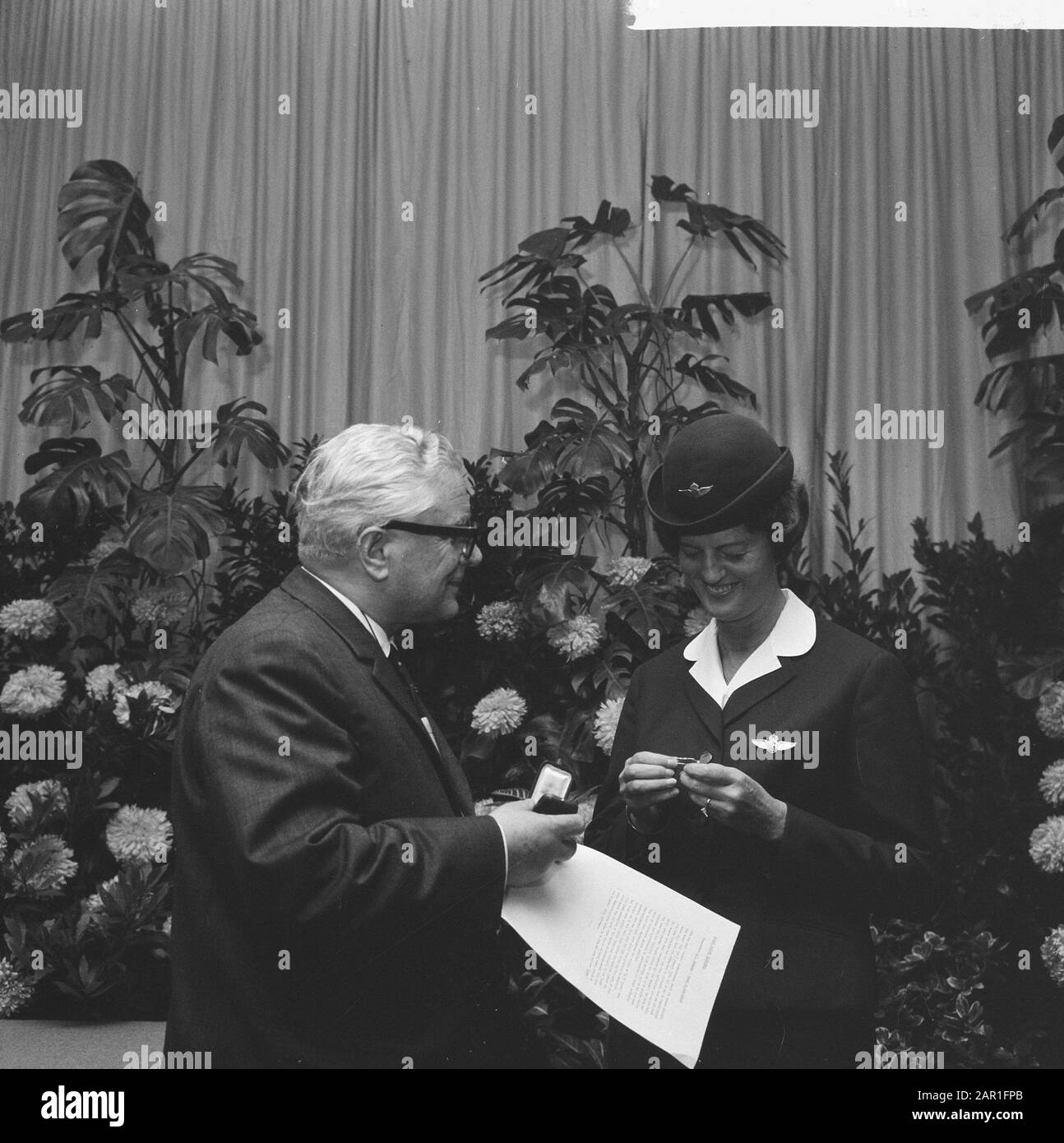 Auszeichnungen für Flugstunden des Vorstandsvorsitzenden der KLM, Dr. G. van der Wal Stewardess, während der Preisverleihung Datum: 18. Oktober 1965 Schlagwörter: Ehrungen, Ehrungen, Mitarbeiter des Flugzeugs Personenname: Wal, G. van der Institutionname: KLM Stockfoto