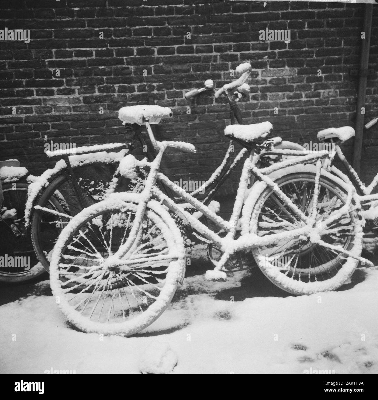 Radsport im Schnee um acht Uhr morgens in Amsterdam Datum: 27. november 1965 Ort: Amsterdam, Noord-Holland Schlagwörter: Fahrräder, Schnee, Stadtbilder Stockfoto