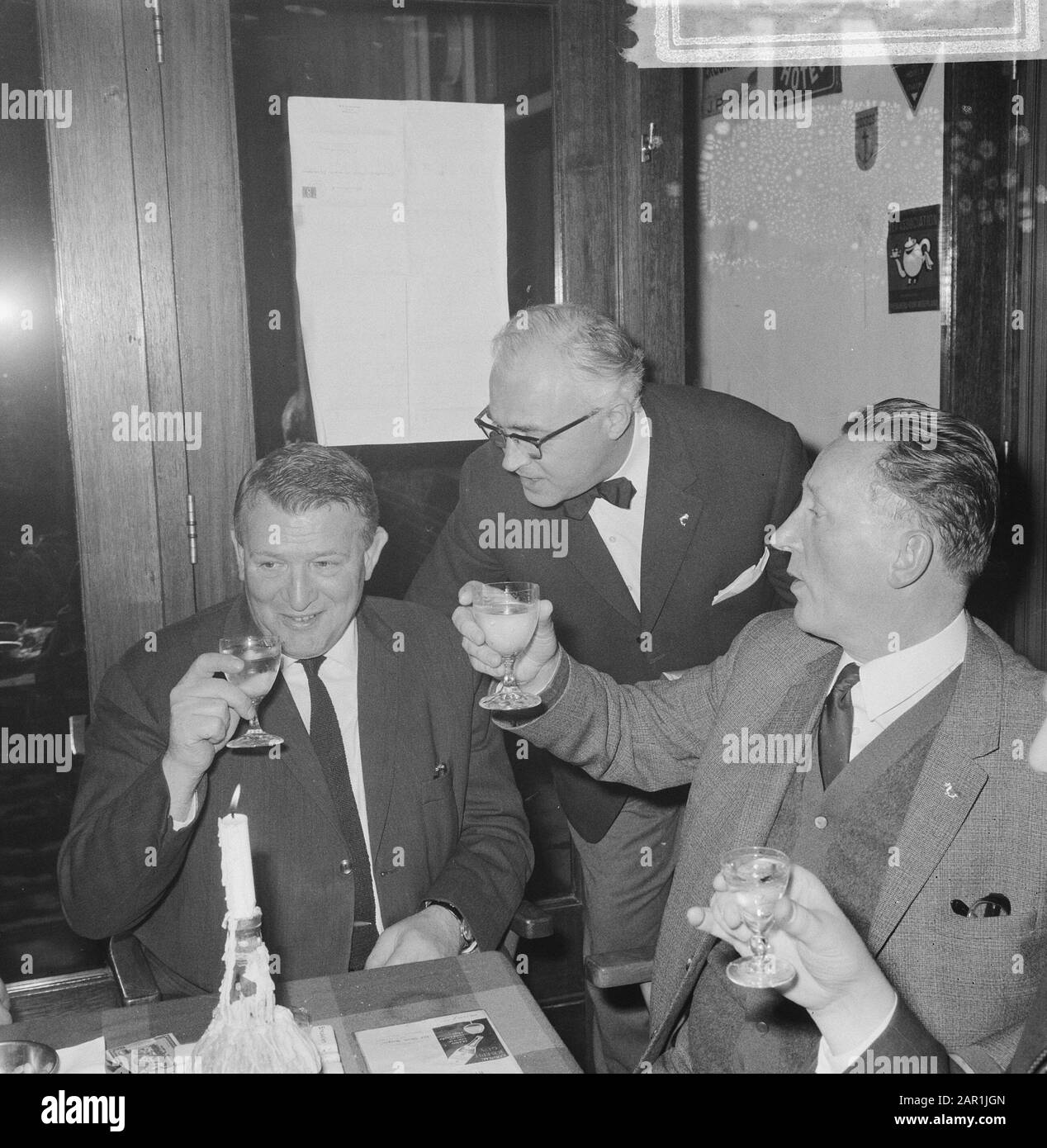 Association Club der Hundert (Fisch); gemütliches Treffen; drei Männer, von denen zwei das Glas-Datum anheben: 16. Dezember 1965 Schlüsselwörter: Alkoholische Getränke, Zusammenkünfte, Toasts, Vereine Stockfoto