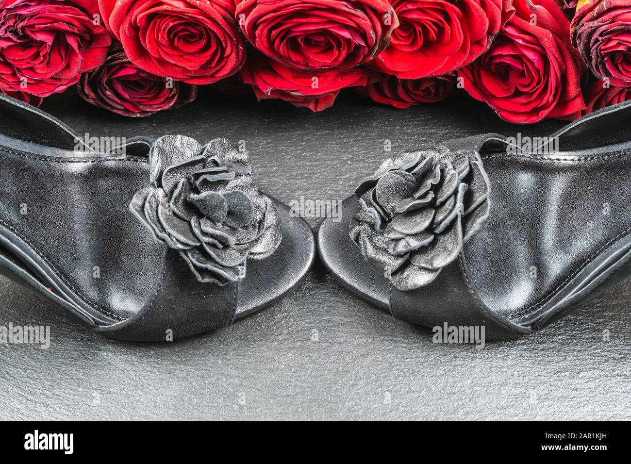 Schuhe mit hohem Absatz, Rosen auf schwarzem Steingrund Stockfotografie -  Alamy