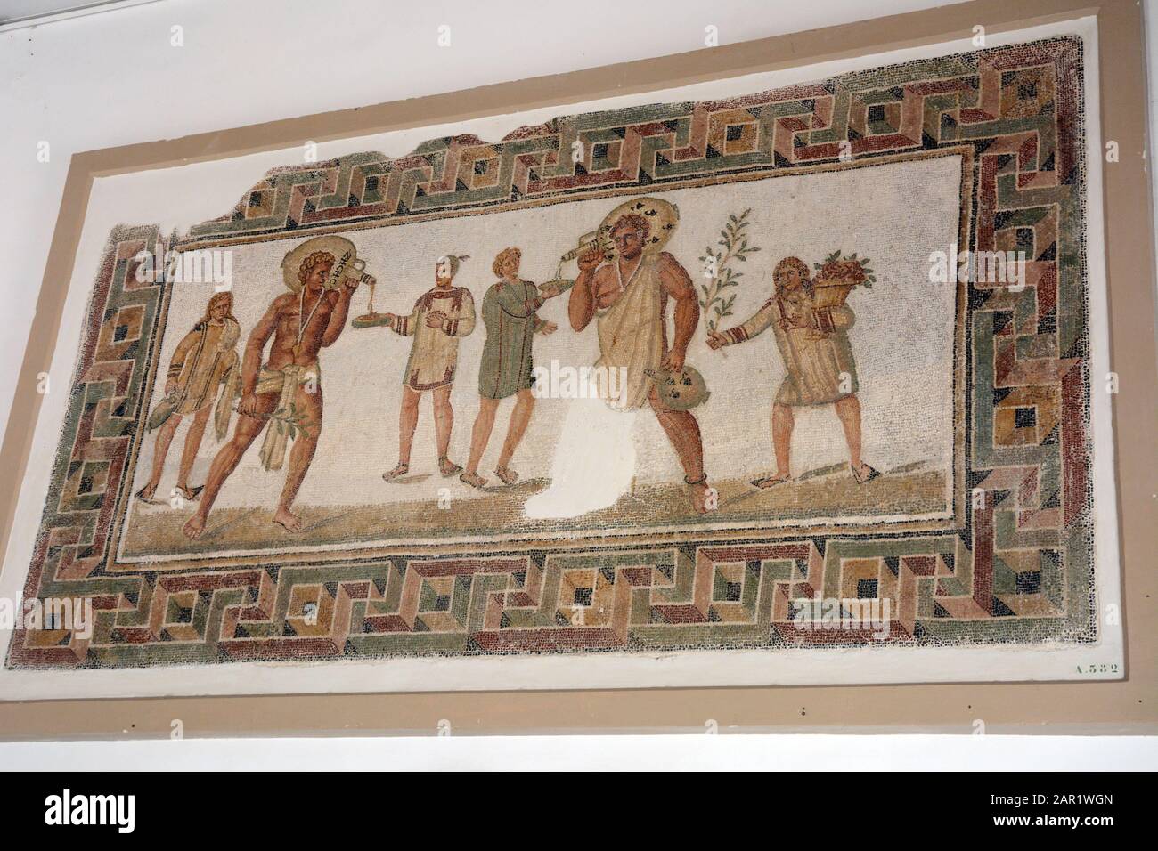 Ein altes römisches Mosaik, das Diener zeigt, die bei einem Bankett Wein aus Tassen gießen, das im Nationalmuseum von Bardo, Tunis, Tunesia, ausgestellt ist. Stockfoto