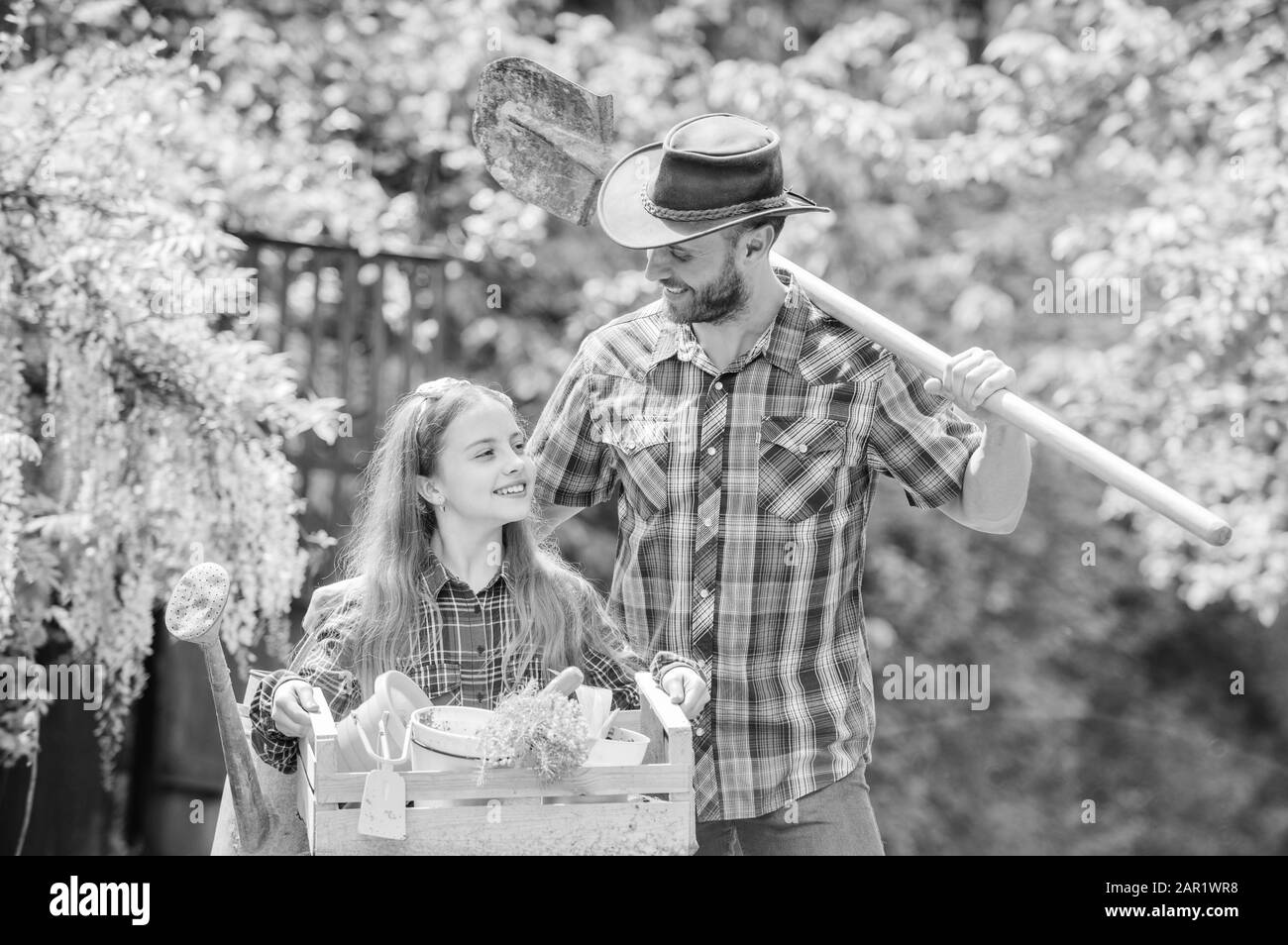 Frühling Dorf Land. Kleines Mädchen und glücklicher Mensch Vati. Tag der Erde. Ökologie. Gartengeräte. Farm der Familie. Sommer Bauernhof. Tochter und Vater auf der Ranch. Bester Service für Sie. Stockfoto