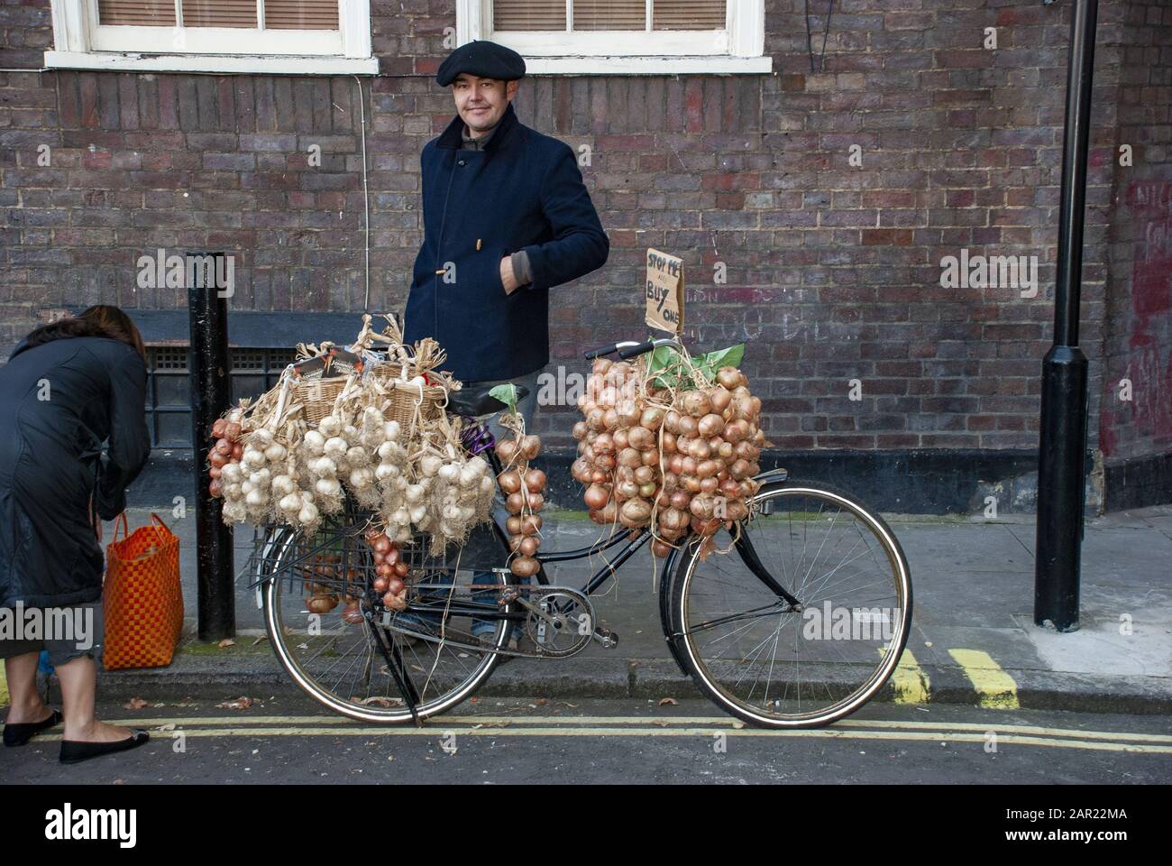 London, GROSSBRITANNIEN - 3. November 2007: Französischer Zwiebelverkäufer mit seinem Fahrrad mit Knoblauch und Zwiebeln Stockfoto