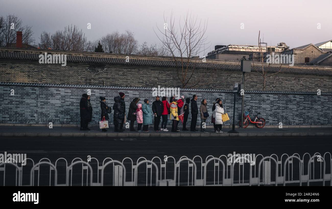 Peking, China - 29. Dezember 2018: Chinesen warten in Folge während eines kalten Winters bei Sonnenuntergang auf den Bus am Busbahnhof. Stockfoto