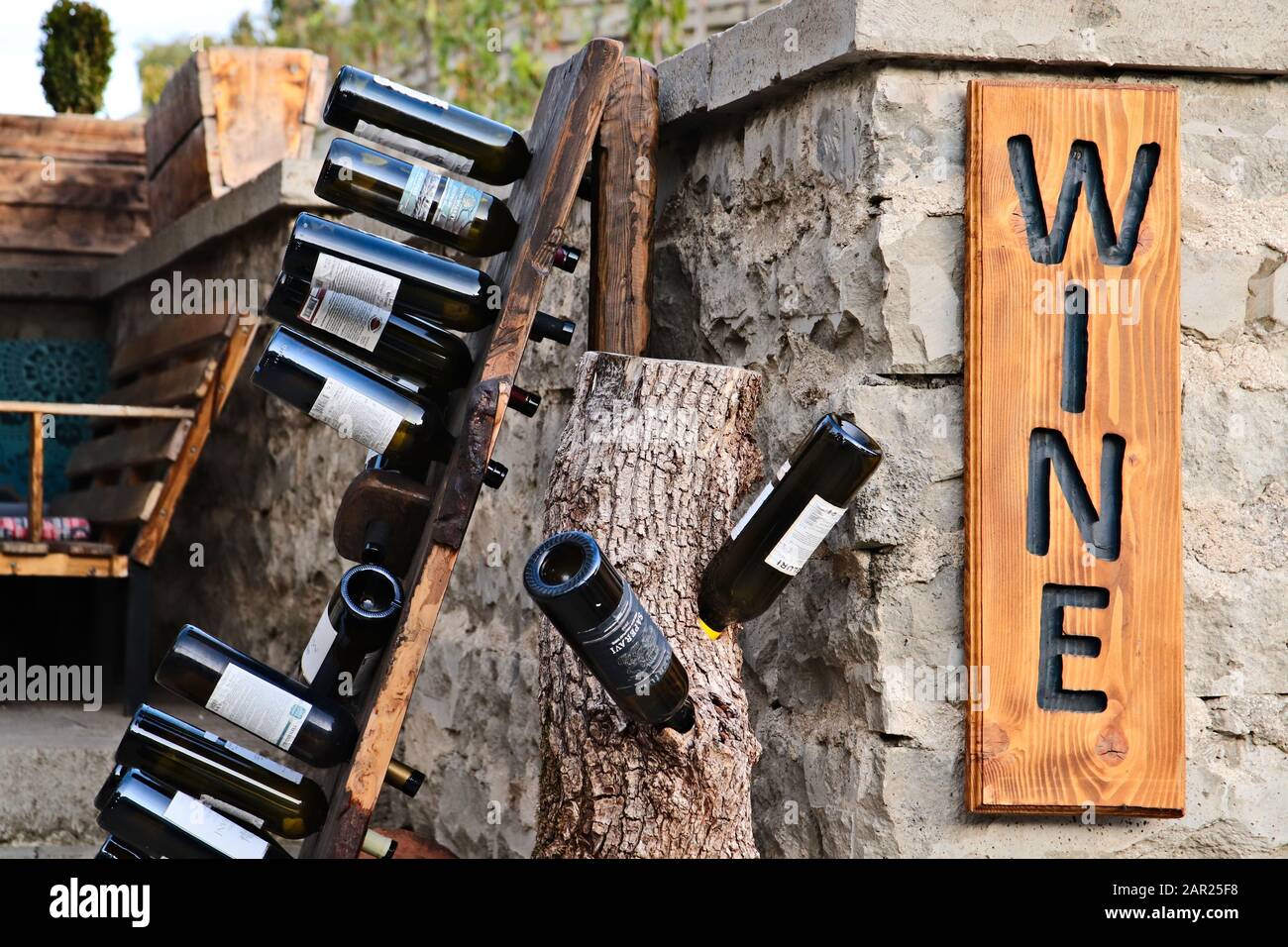 Tiflis, GEORGIEN - 24. September 2019: Eine Sammlung leerer georgischer Weinflaschen auf einem Holzgestell. Bild des Konzepts der Weinverkostung. Stockfoto