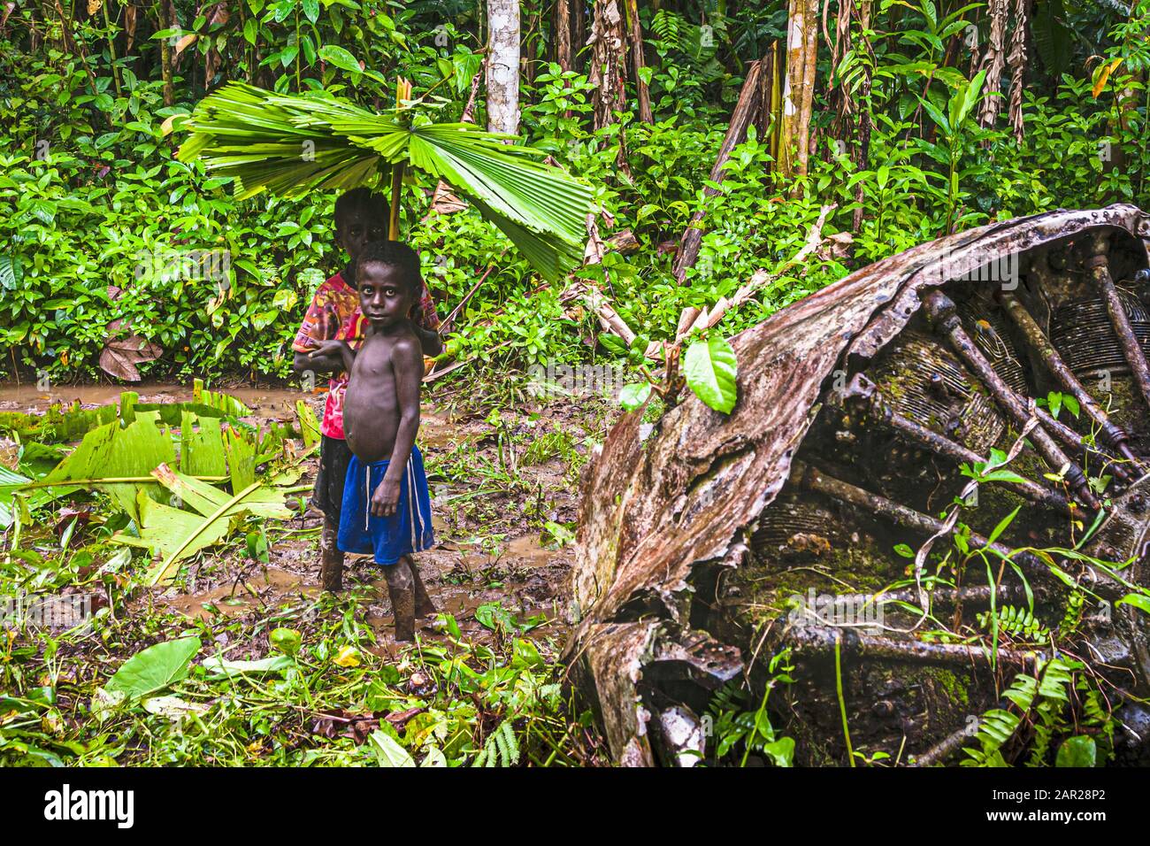 Zwei Jungs mit selbstgemachten Regenschirmen im Dschungel von Bougainville Stockfoto