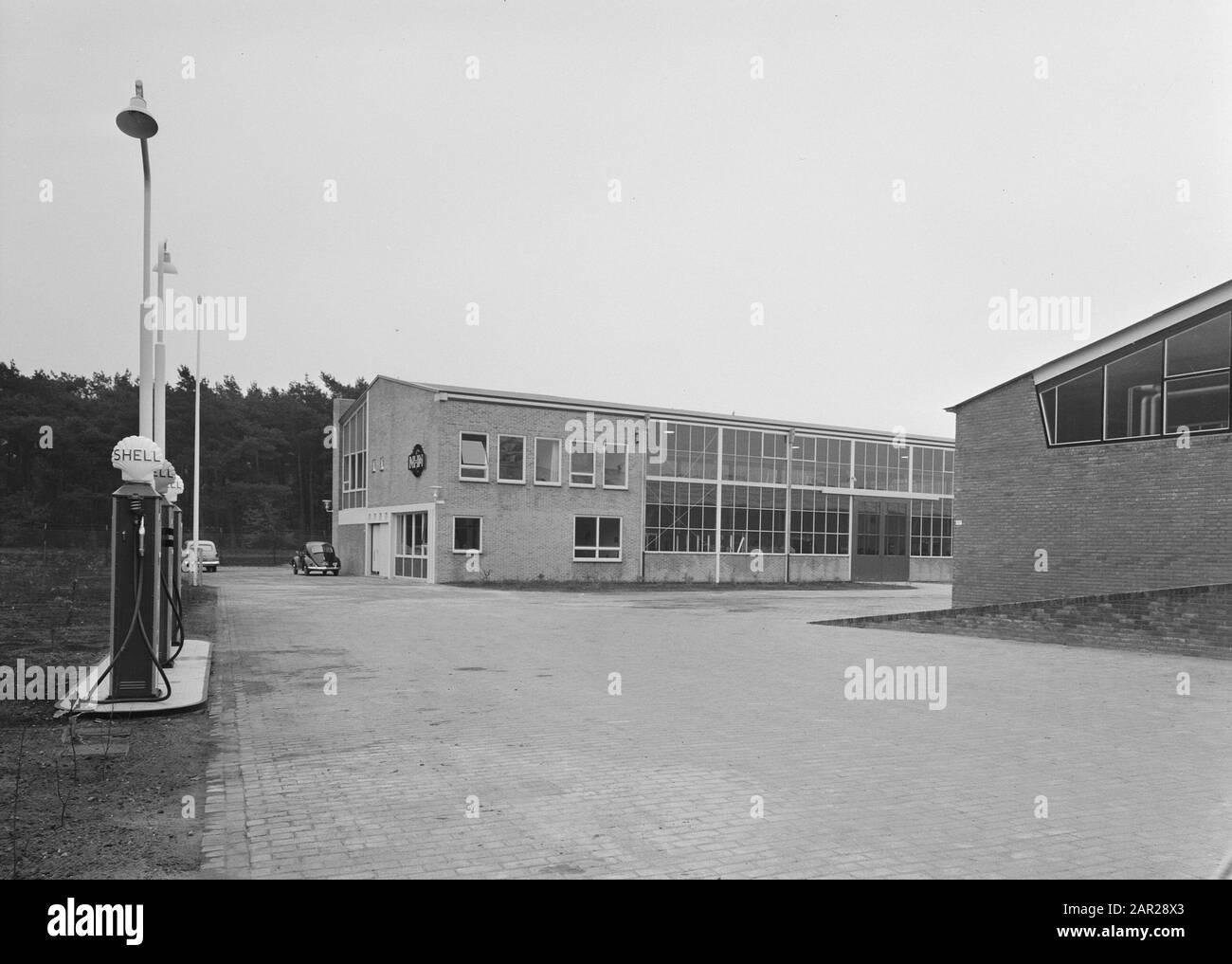 Hangar und Benzinpumpe am Koningsweg van de Nederlandse Heideme Anmerkung: Nu IPC Green Space (rot. 2016) Datum: November 1958 Standort: Arnhem, Gelderland Schlüsselwörter: Hangars, Workshops Stockfoto