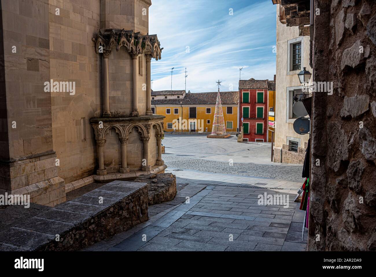 Straße neben der Kathedrale und im Hintergrund der Hauptplatz der mittelalterlichen Stadt Cuenca mit seinen alten Gebäuden und Weihnachtsornamenten. Europa Spai Stockfoto