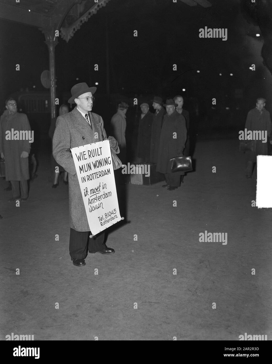 Wer findet mein Zuhause? Mann mit Schild auf der Suche nach Wohnraum in Amsterdam Datum: 20. Januar 1950 Ort: Amsterdam Schlagwörter: Wohnungsnot Stockfoto
