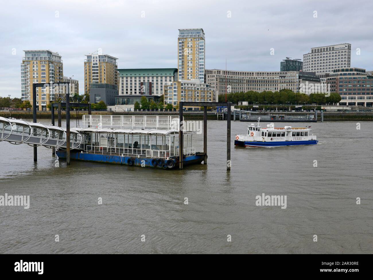 Eine Fähre nähert sich dem Nelson Dock Pier von Canary Wharf über die Themse, London, Großbritannien Stockfoto