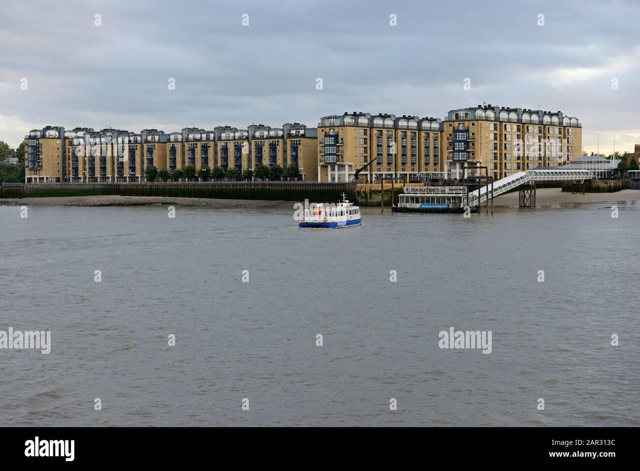 Eine Fähre nähert sich dem Nelson Dock Pier von Canary Wharf, London, Großbritannien Stockfoto