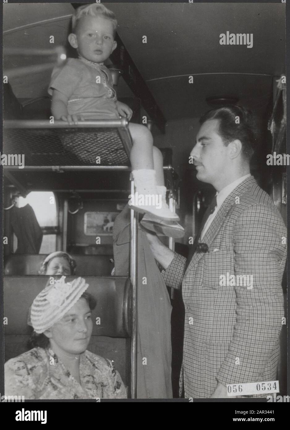 Wegen des Urlaubsdrucks ist es schwierig, einen Sitz im Zug zu finden. Ein Kind befindet sich im Gepäcknetz Datum: 7. August 1952 Stockfoto