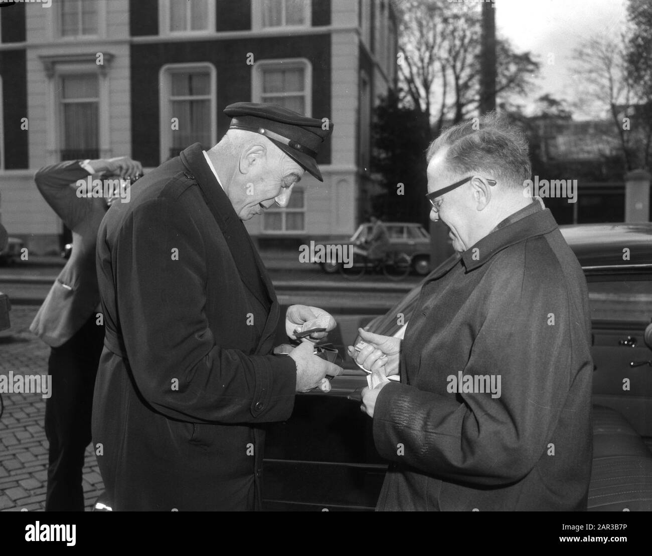 Kabinettskrise 1966: De Nacht van Schmelzer Gruppenvorsitzender der KVP Herr C.J. van der Ploeg zahlt Taxifahrer Datum: 19. Oktober 1966 Standort: Den Haag, Zuid-Holland Schlüsselwörter: Fahrer, Kabinettskrisen, Parlamentarier, politischer Personenname: Ploeg, Cornelis Johannes van der Stockfoto