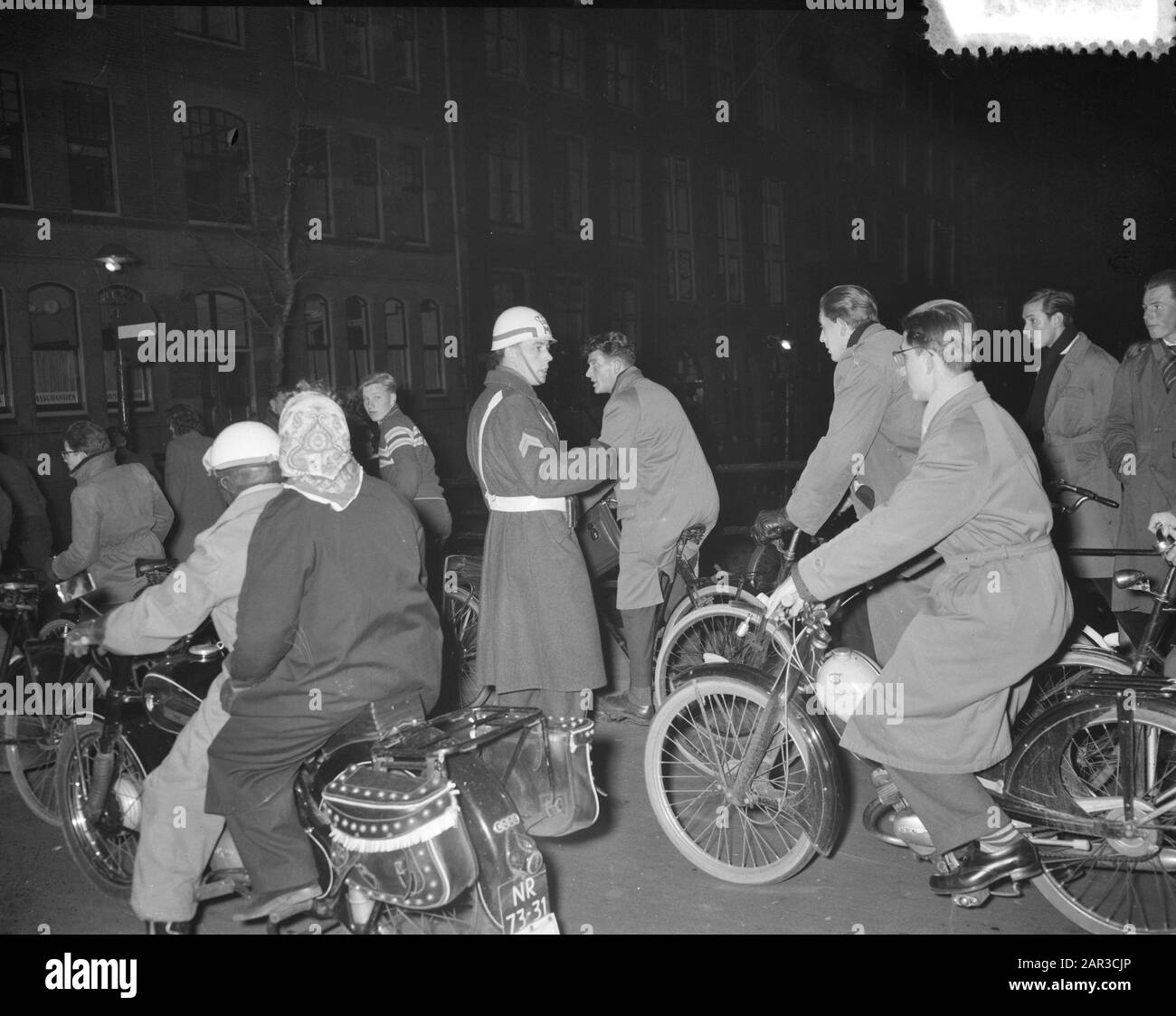 Gedenkabend auf dem Damplatz in Amsterdam, nach dem ungarischen Aufstand. Marechaussee in Aktion Datum: 5. November 1956 Ort: Amsterdam, Ungarn Schlagwörter: Demonstrationen, Radfahrer, Gedenkfeiern, Militär Stockfoto