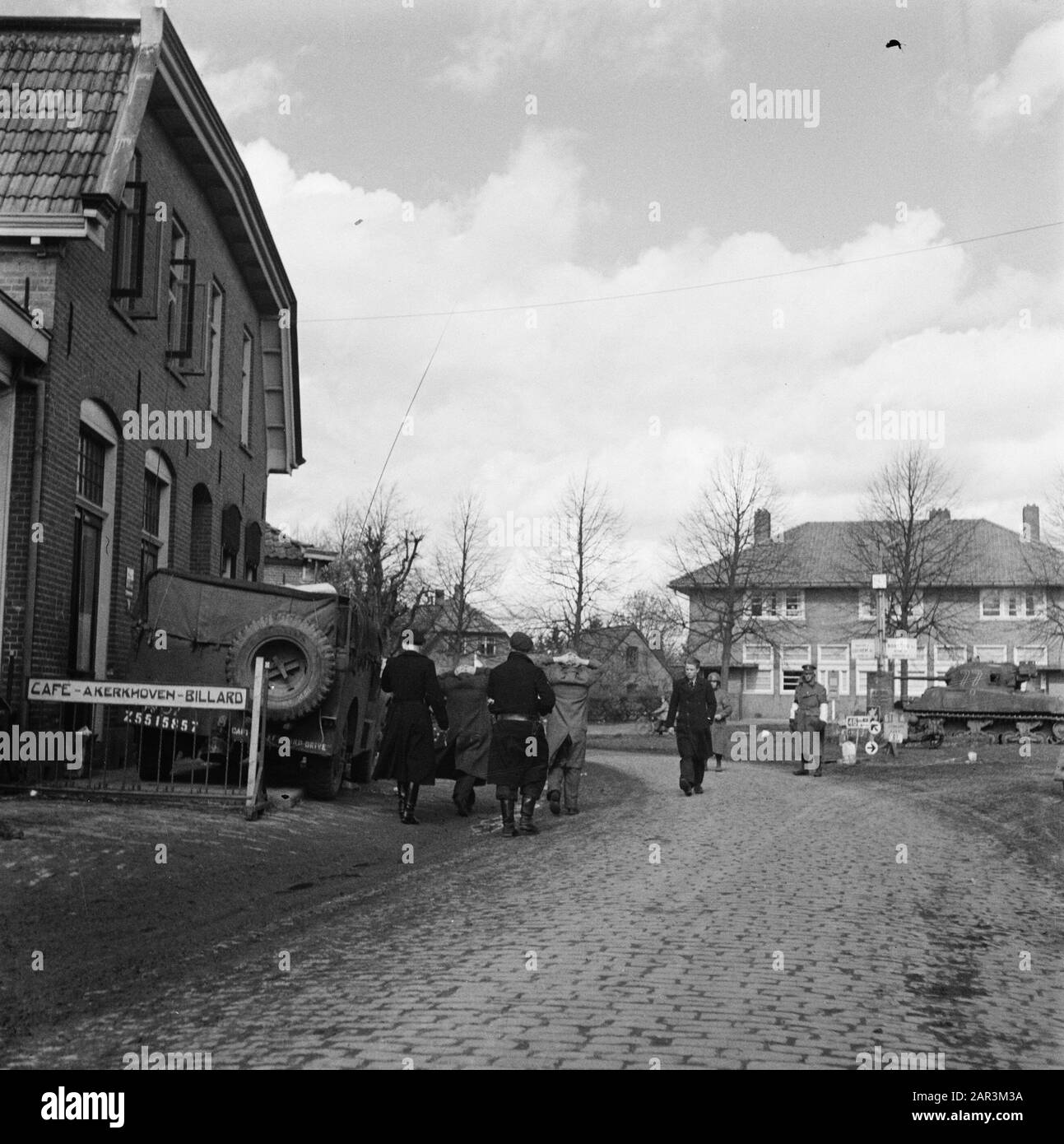 Front Nord-Ost Niederlande: Enschede - Hengelo [Schlacht en liberrijding Achterhoek (1. April 1945), Enschede (1. April 1945), Hengelo (3. April 1945)] Ruurlo, Dorpsstraat Thv Julianaplein. NSB-Leute werden herangeführt. Linkes Café A. Kerkhoven. Ein Sherman-Tank auf der rechten Seite. Vor dem Verkehrszeichen ein englisches MP Datum: April 1945 Ort: Enschede, Hengelo, Overijssel Schlüsselwörter: NSB, Fronten, Zweiter Weltkrieg Stockfoto