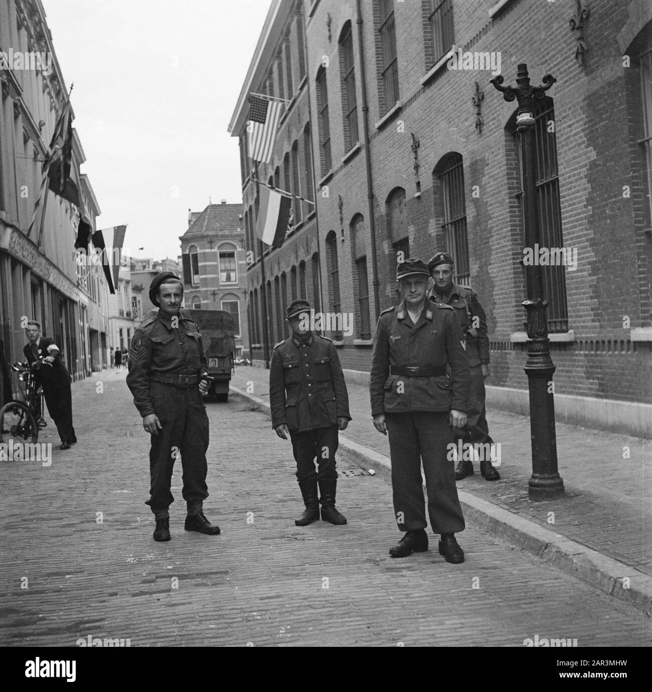 Kriegsverbrecher Zwei Mitglieder der Brigade Prinzessin Irene mit links zwei gefangenen deutschen Soldaten vor dem Haus der Untersuchungshaft Anmerkung: Das deutsche Militärrecht stammt von der Luftwaffe oder einem Fallschirmjäger Datum: 1945 Ort: Amsterdam, Noord-Holland Schlüsselwörter: Befreiung, Weltkrieg Stockfoto