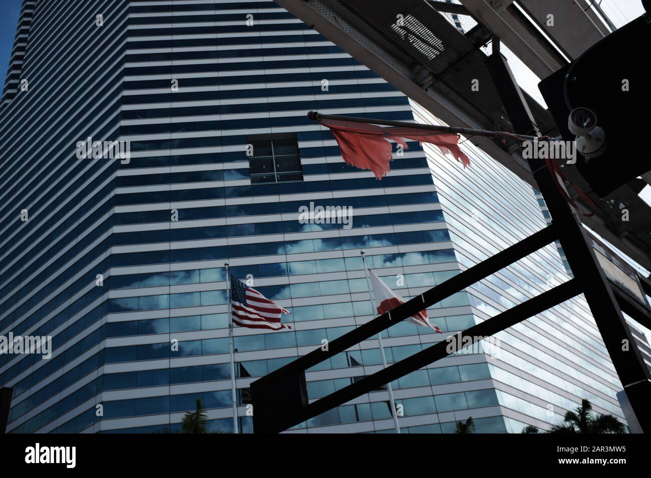 Blick auf das Gebäude des Miami Tower in der Innenstadt von Miami mit Fahnen und Metromover Gleisen im Rahmen Stockfoto